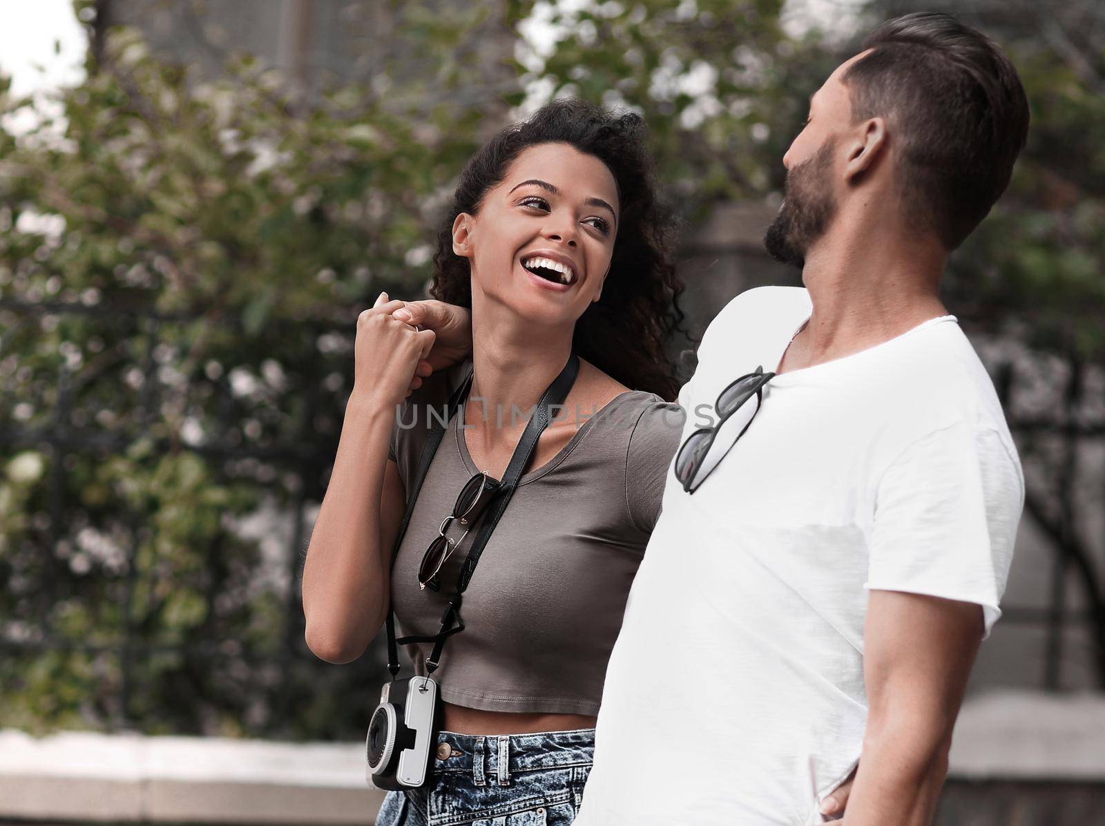 Cheerful young couple walking on urban street by asdf