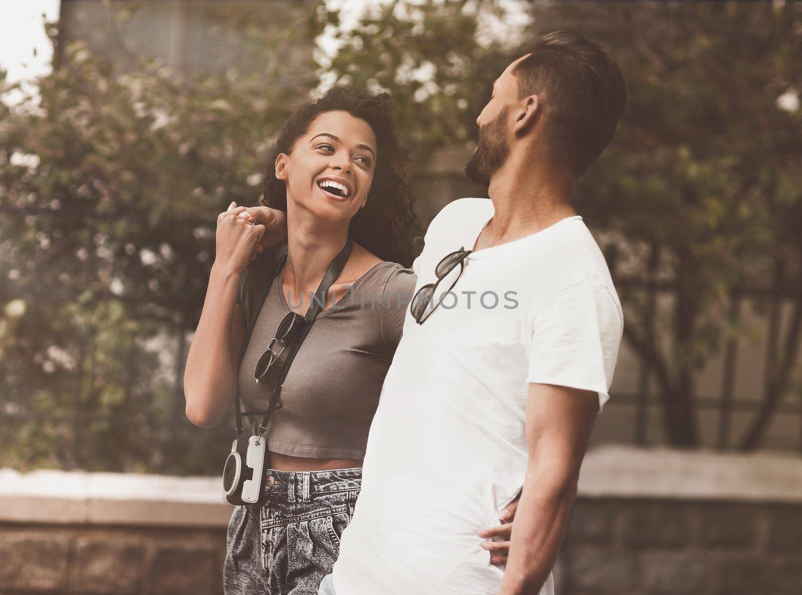 Happy young couple walking in the summer park