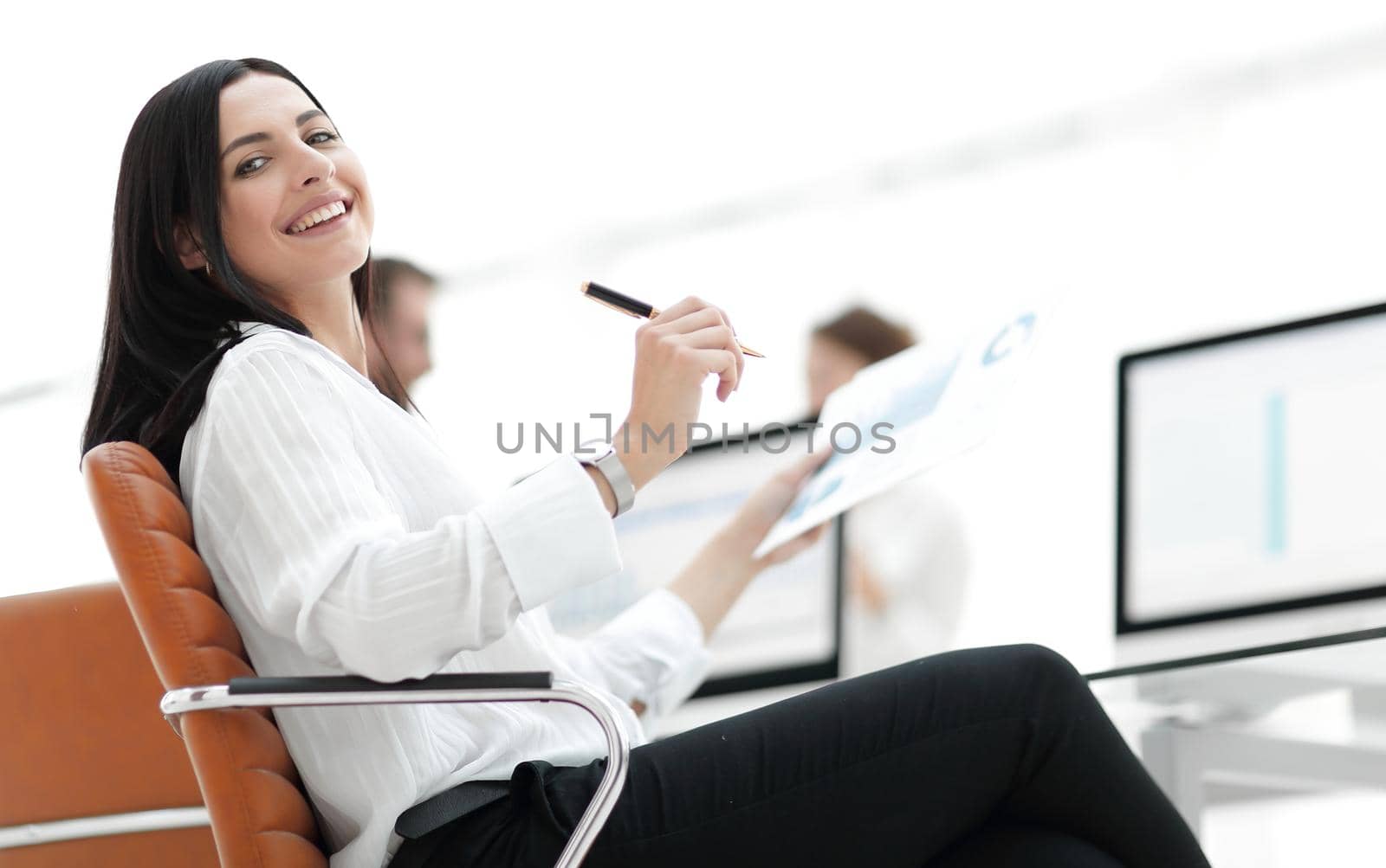 smiling business woman with financial documents sitting at work desk. by asdf