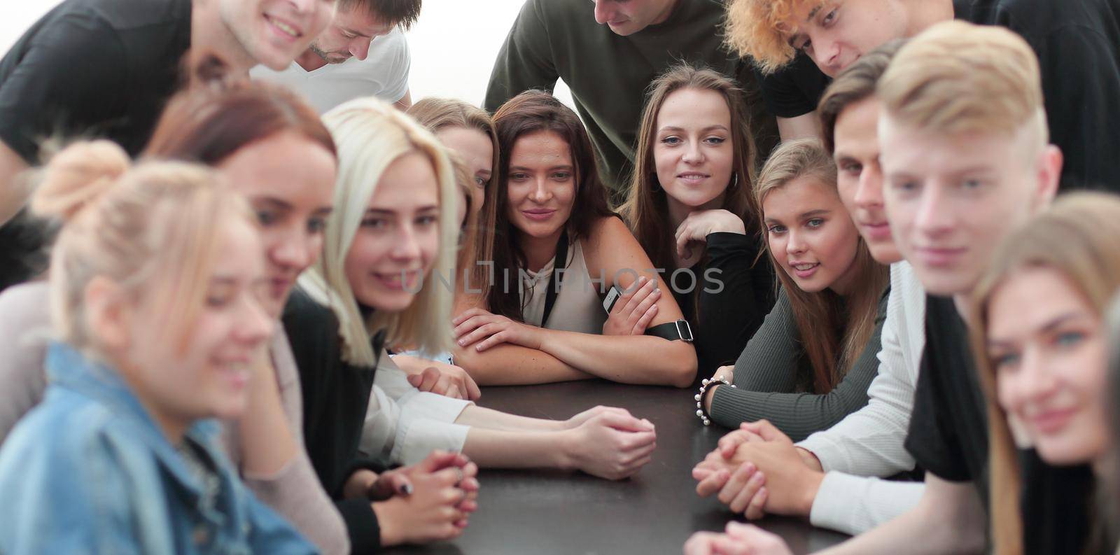 group of young people sitting at a large table by asdf