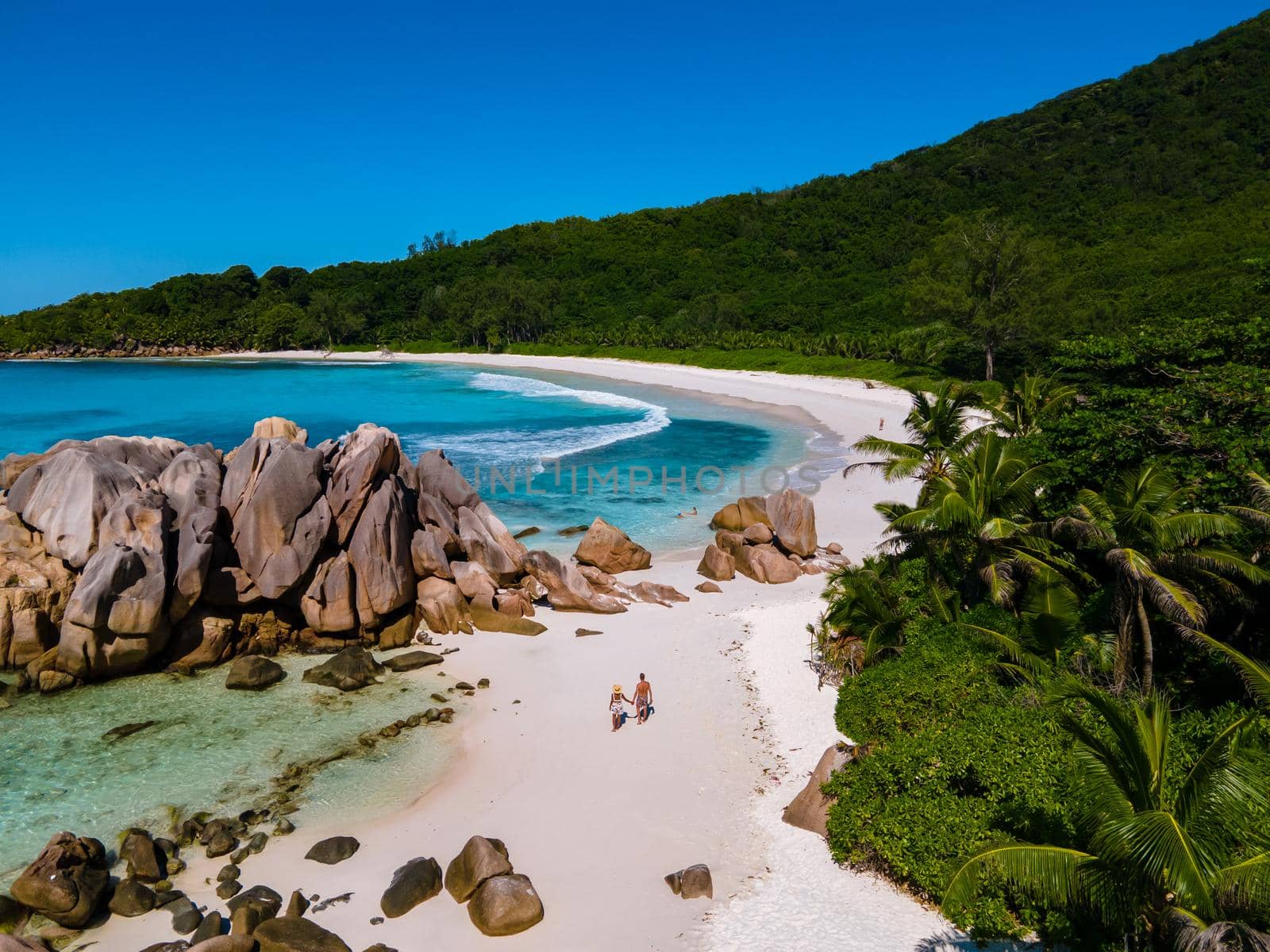 Anse Cocos La Digue Seychelles, a young couple of men and women on a tropical beach during a luxury vacation in Seychelles. Tropical beach Anse Cocos La Digue Seychelles.