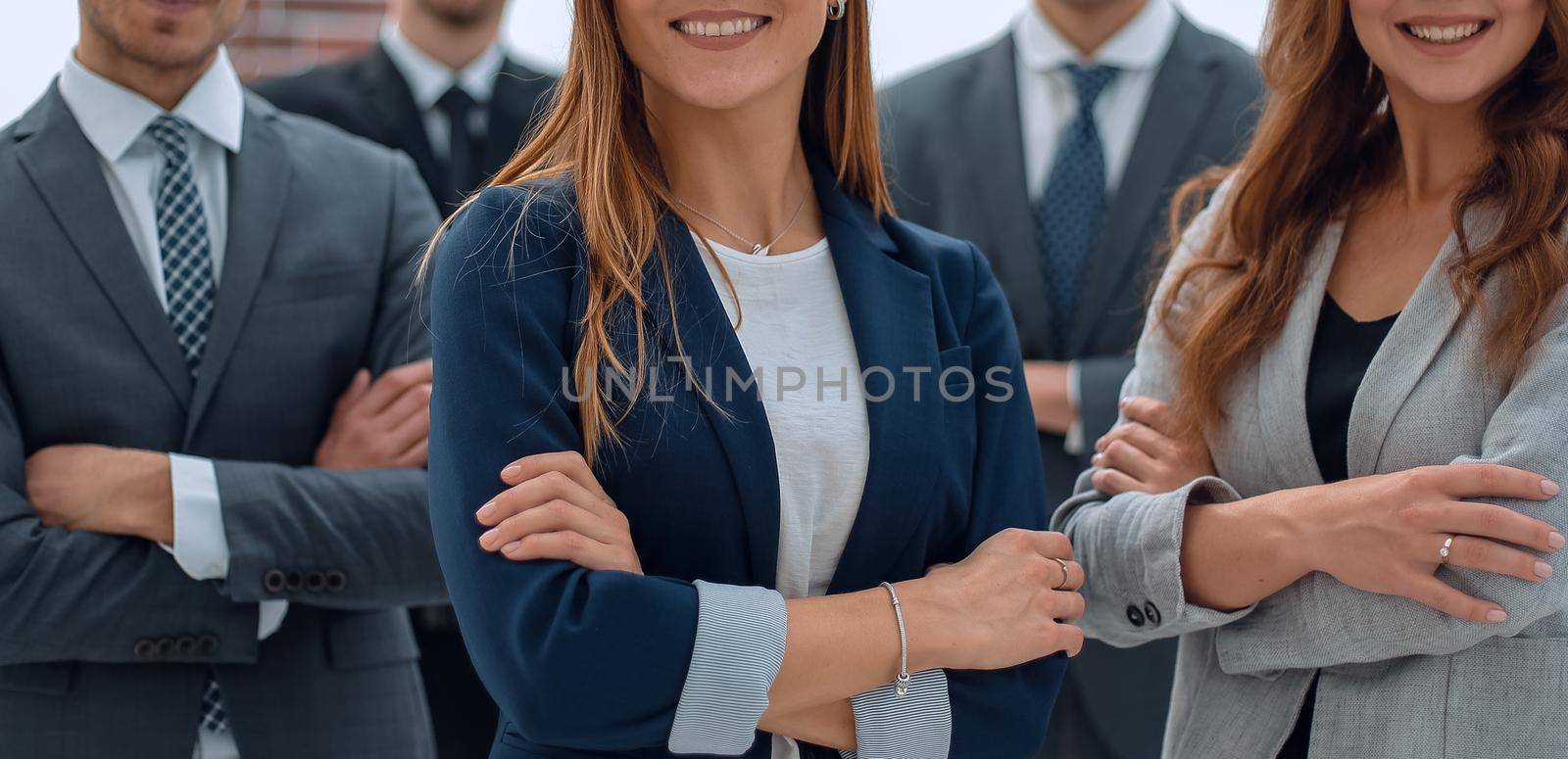 group of cheerful business people with arms crossed in a modern office