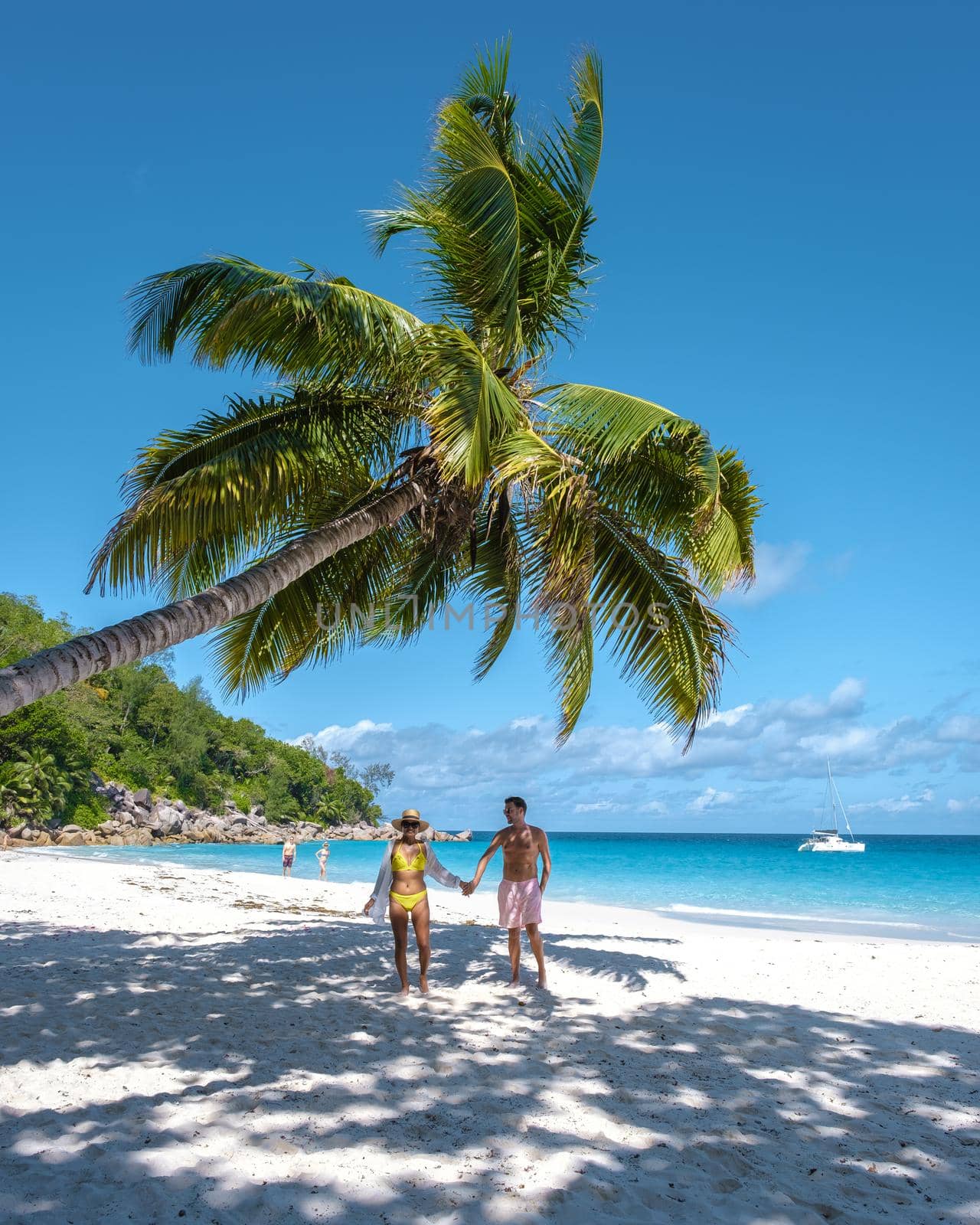 Anse Georgette Praslin Seychelles, young couple men and woman on a tropical beach during a luxury vacation in the Seychelles. Tropical beach Anse Georgette Praslin Seychelles by fokkebok