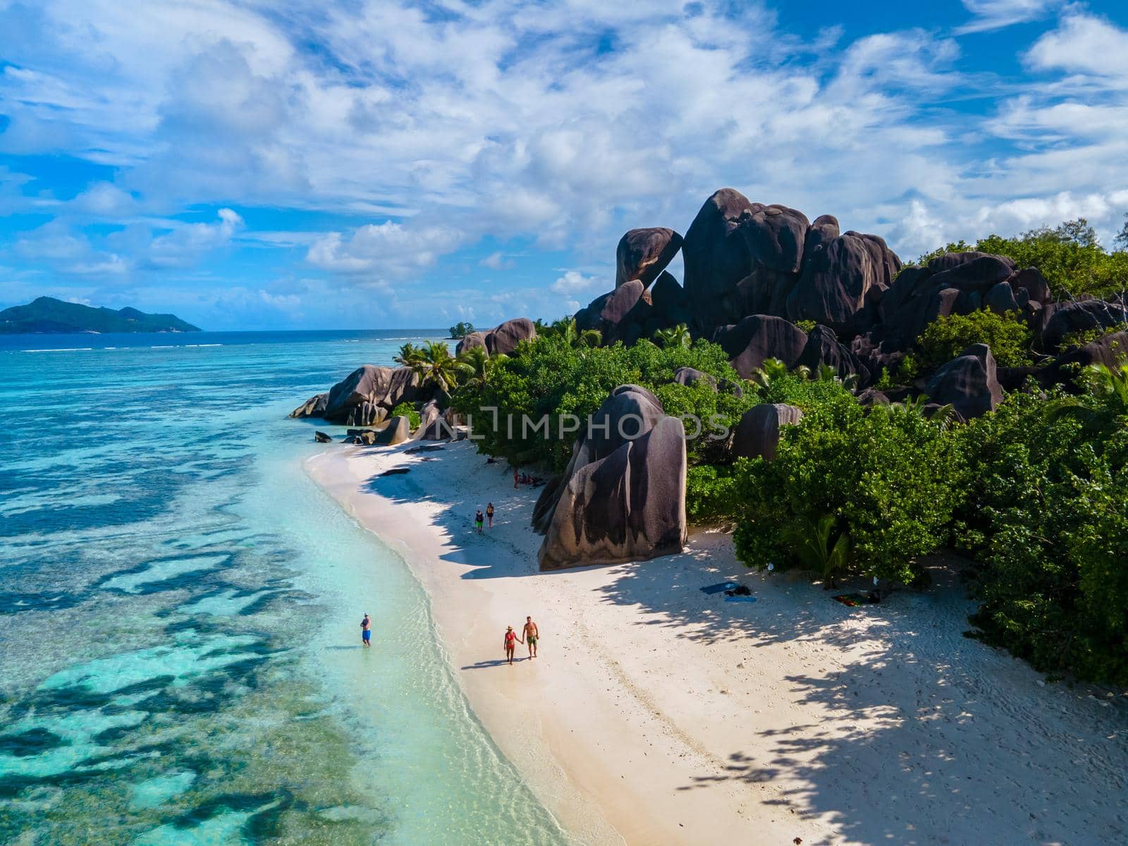 Anse Source d'Argent, La Digue Seychelles, a young couple of men and women on a tropical beach during a luxury vacation in Seychelles. Tropical beach Anse Source d'Argent, La Digue Seychelles