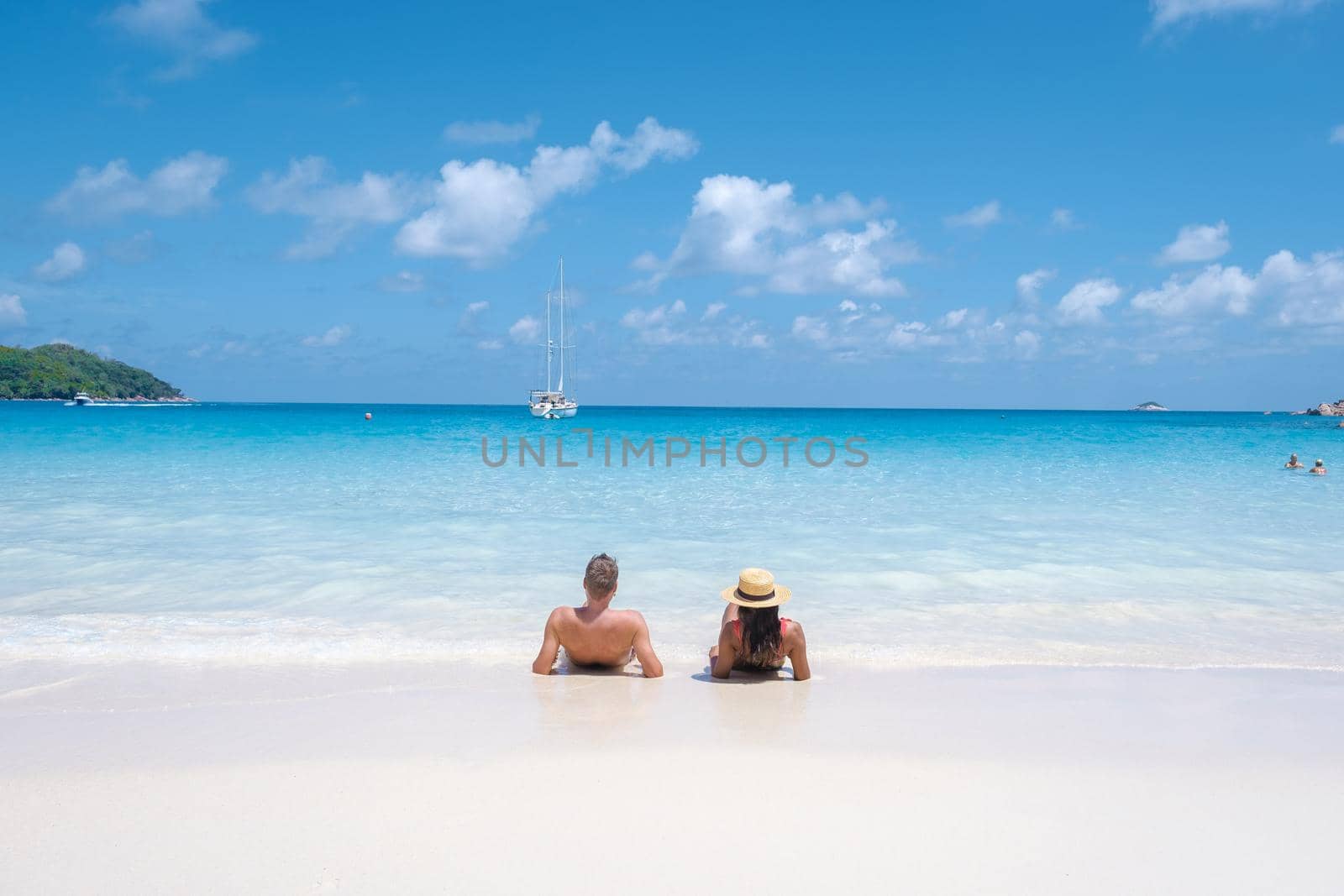 Anse Lazio Praslin Seychelles, a young couple of men and women on a tropical beach during a luxury vacation in Seychelles. Tropical beach Anse Lazio Praslin Seychelles