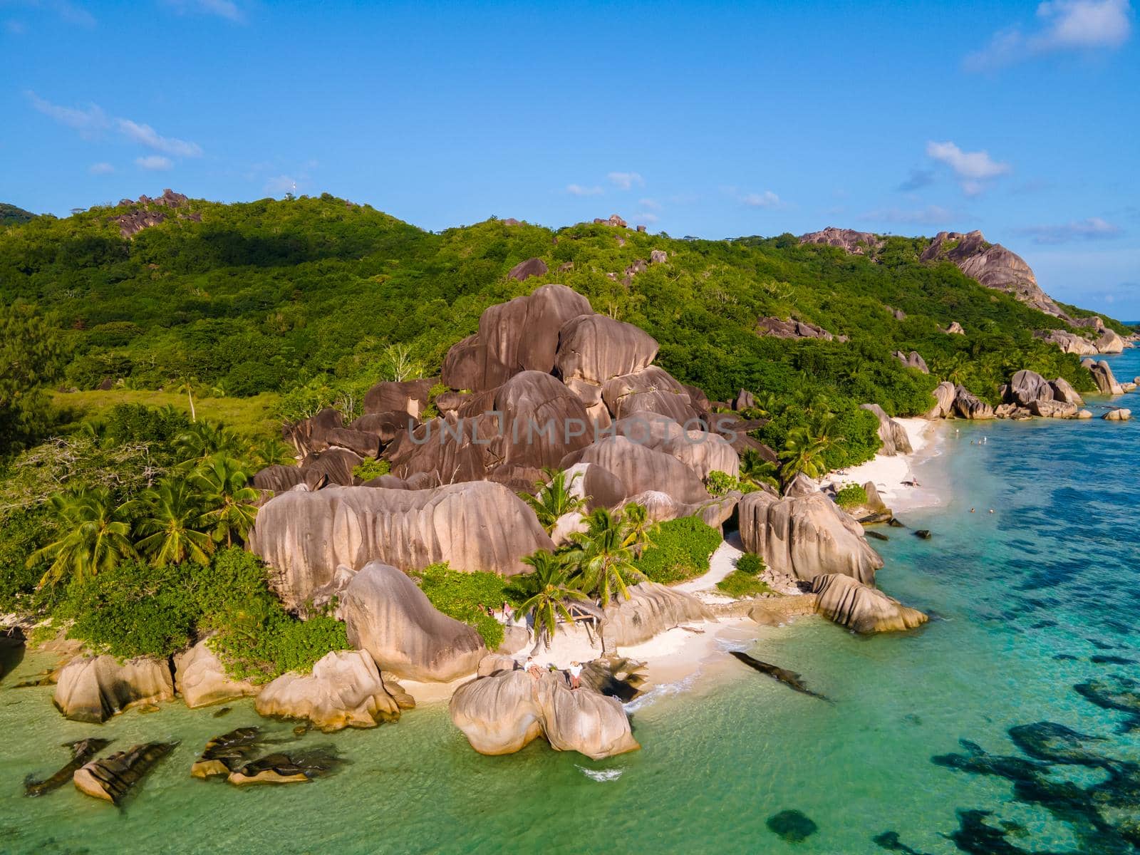 Anse Source d'Argent, La Digue Seychelles, a young couple of men and women on a tropical beach during a luxury vacation in Seychelles. Tropical beach Anse Source d'Argent, La Digue Seychelles