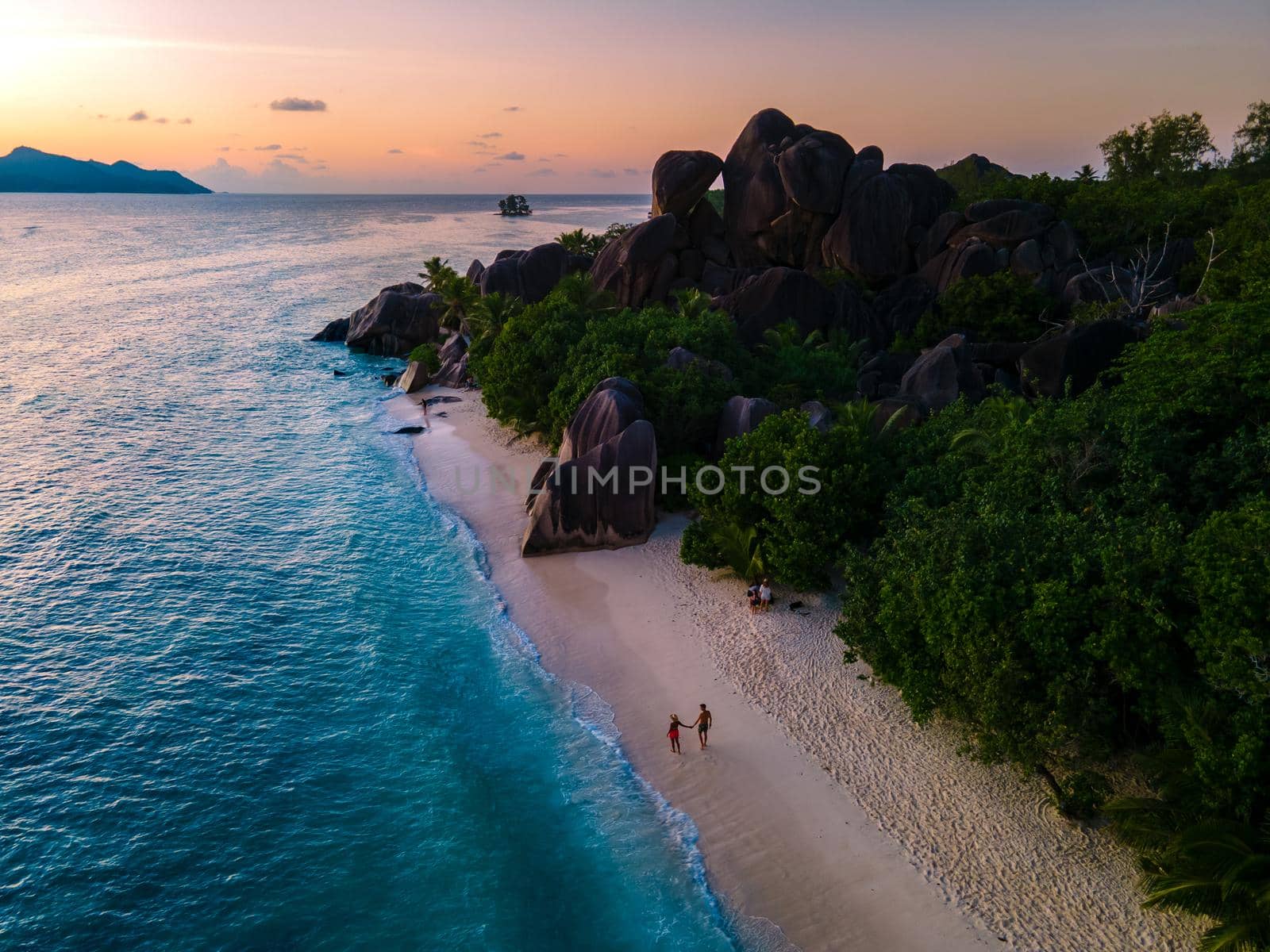 Anse Source d'Argent, La Digue Seychelles, a young couple of men and women on a tropical beach during a luxury vacation in Seychelles. Tropical beach Anse Source d'Argent, La Digue Seychelles