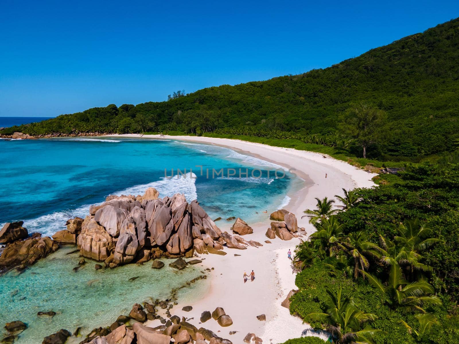 Anse Cocos La Digue Seychelles, a young couple of men and women on a tropical beach during a luxury vacation in Seychelles. Tropical beach Anse Cocos La Digue Seychelles.