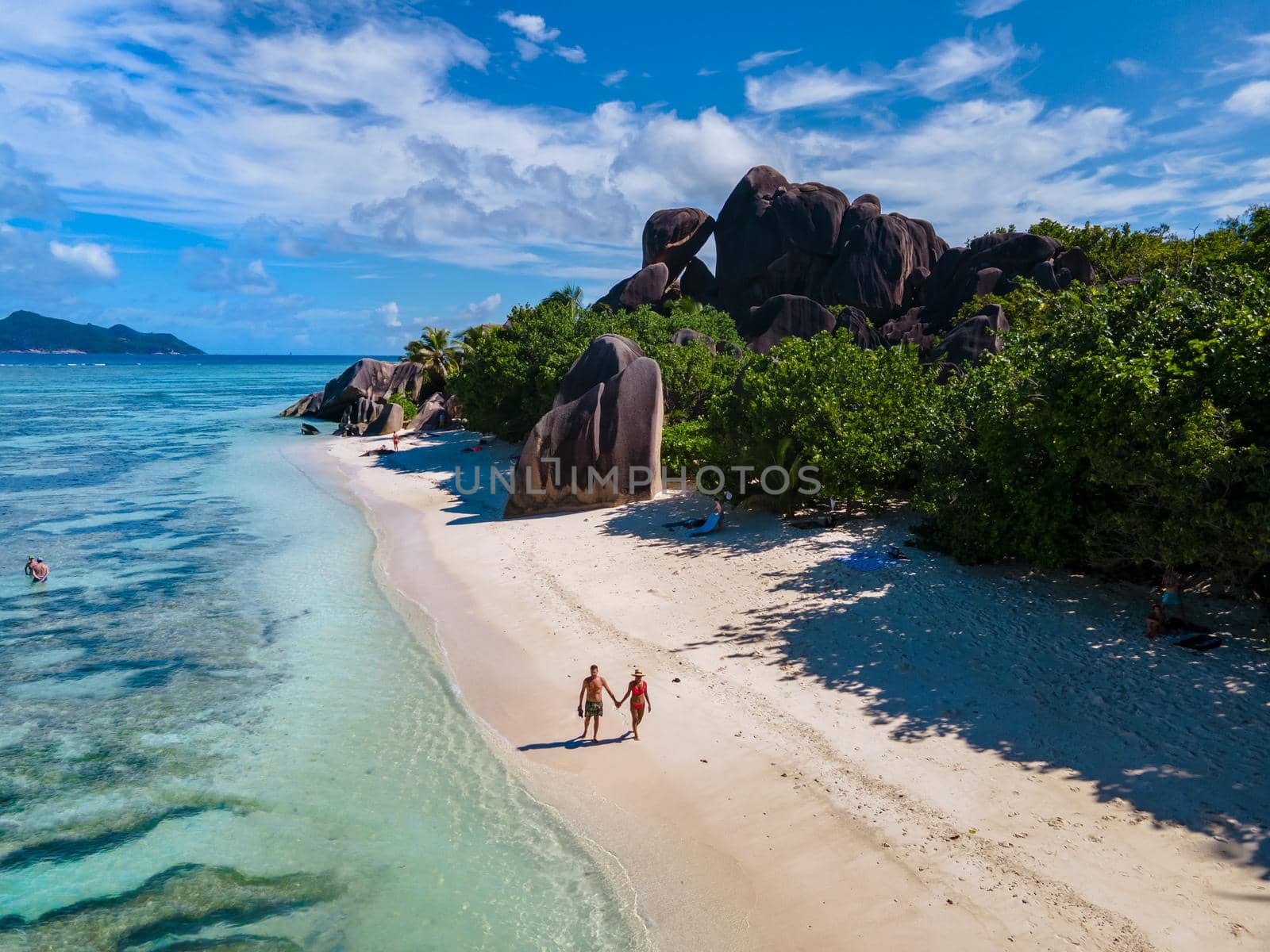 Anse Source d'Argent, La Digue Seychelles, a young couple of men and women on a tropical beach during a luxury vacation in Seychelles. Tropical beach Anse Source d'Argent, La Digue Seychelles