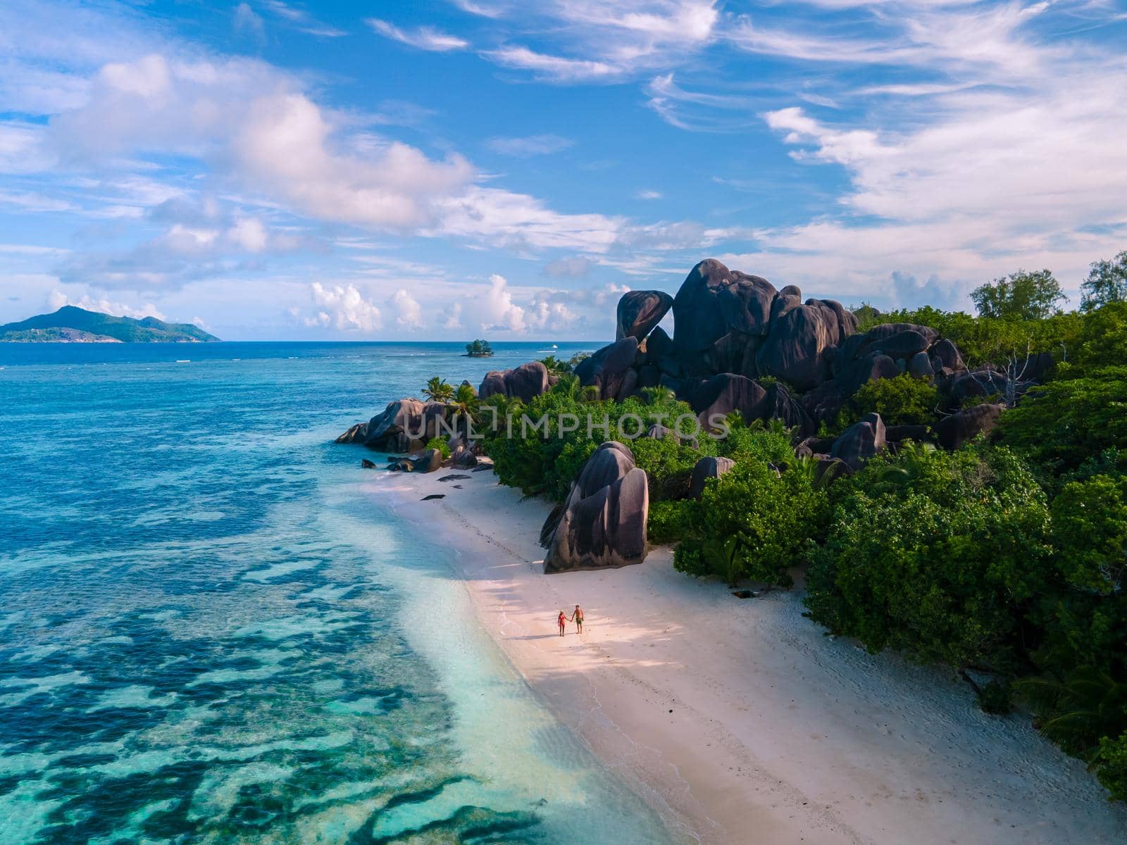 Anse Source d'Argent, La Digue Seychelles, a young couple of men and women on a tropical beach during a luxury vacation in Seychelles. Tropical beach Anse Source d'Argent, La Digue Seychelles