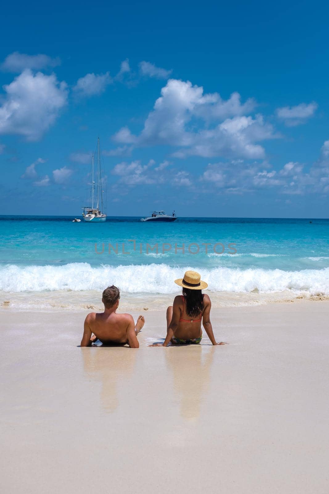 Anse Lazio Praslin Seychelles, young couple men and woman on a tropical beach during a luxury vacation in the Seychelles. Tropical beach Anse Lazio Praslin Seychelles by fokkebok