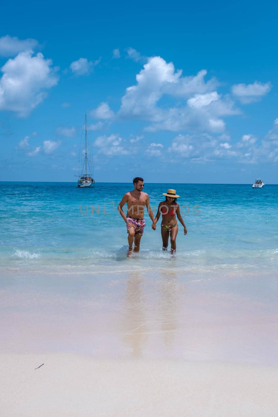 Anse Lazio Praslin Seychelles, a young couple of men and women on a tropical beach during a luxury vacation in Seychelles. Tropical beach Anse Lazio Praslin Seychelles