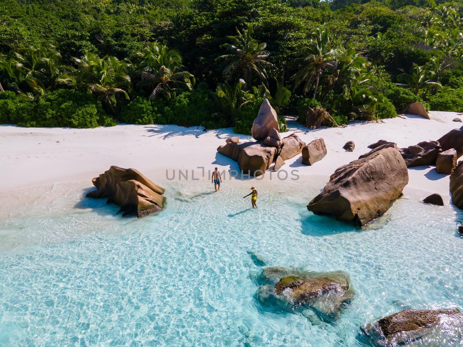 Anse Cocos La Digue Seychelles, a young couple of men and women on a tropical beach during a luxury vacation in Seychelles. Tropical beach Anse Cocos La Digue Seychelles.