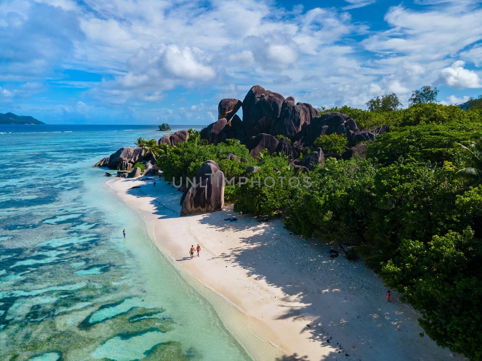 Anse Source d'Argent, La Digue Seychelles, a young couple of men and women on a tropical beach during a luxury vacation in Seychelles. Tropical beach Anse Source d'Argent, La Digue Seychelles