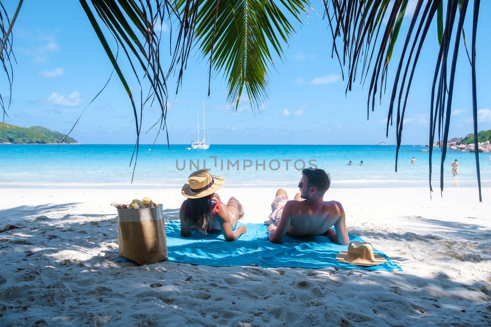 Anse Lazio Praslin Seychelles, young couple men and woman on a tropical beach during a luxury vacation in the Seychelles. Tropical beach Anse Lazio Praslin Seychelles by fokkebok