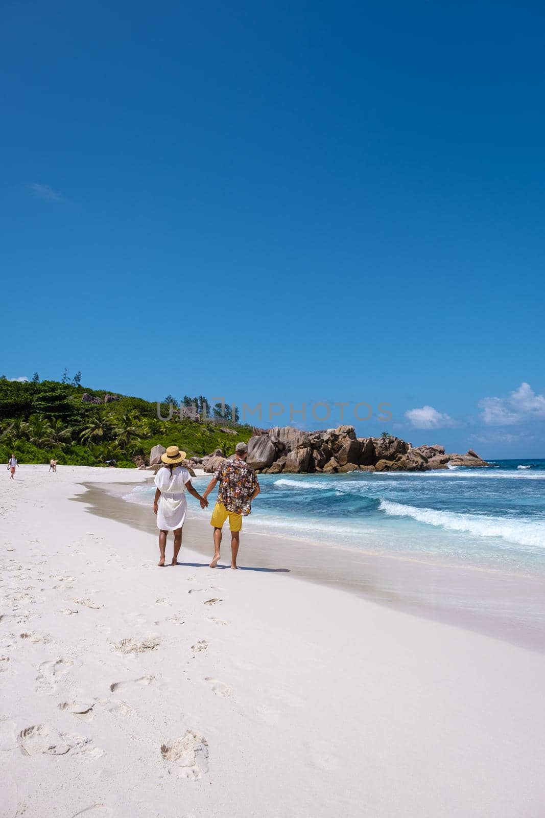 Anse Cocos La Digue Seychelles, young couple men and woman on a tropical beach during a luxury vacation in the Seychelles. Tropical beach Anse Cocos La Digue Seychelles by fokkebok