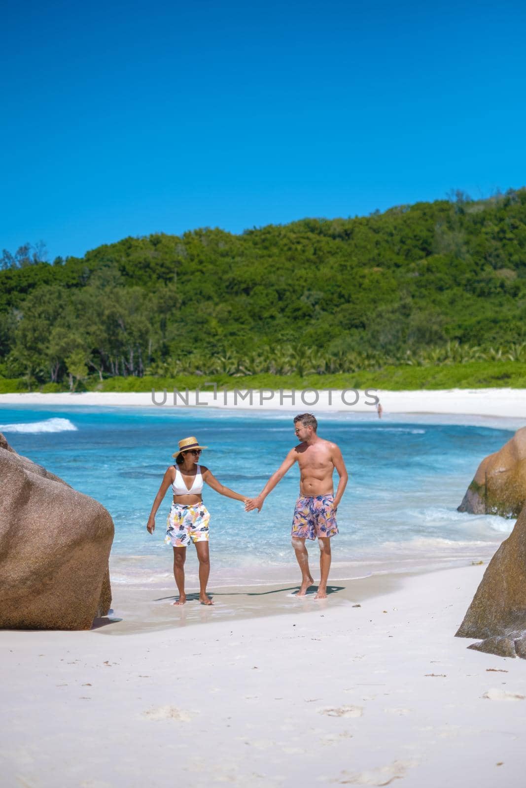 Anse Cocos La Digue Seychelles, a young couple of men and women on a tropical beach during a luxury vacation in Seychelles. Tropical beach Anse Cocos La Digue Seychelles.