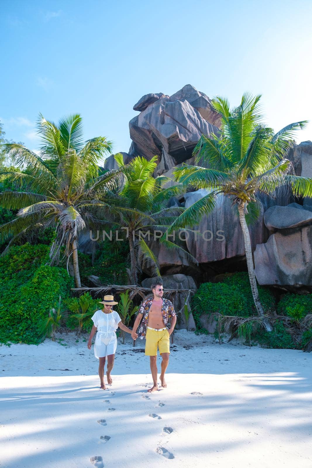 Anse Cocos La Digue Seychelles, young couple men and woman on a tropical beach during a luxury vacation in the Seychelles. Tropical beach Anse Cocos La Digue Seychelles by fokkebok