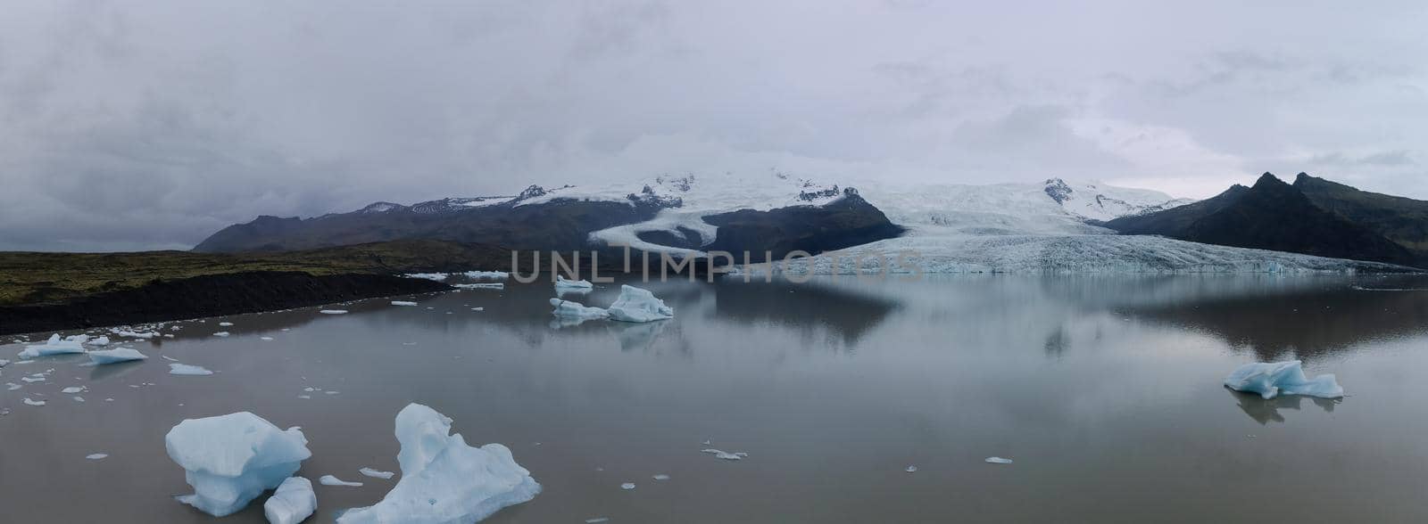 Massive glacier tongue with lake and icebergs panorama