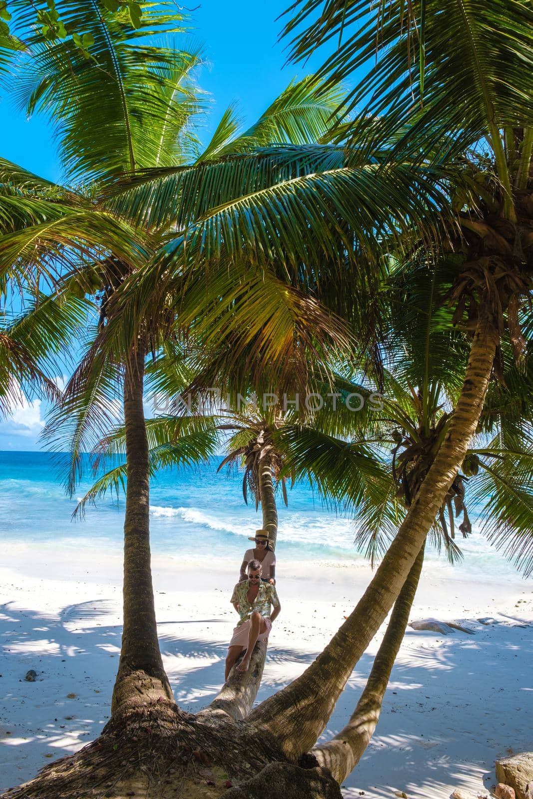 Anse Patates, La Digue Seychelles, a young couple of men and women on a tropical beach during a luxury vacation in Seychelles. Tropical beach Anse Patates, La Digue Seychelles