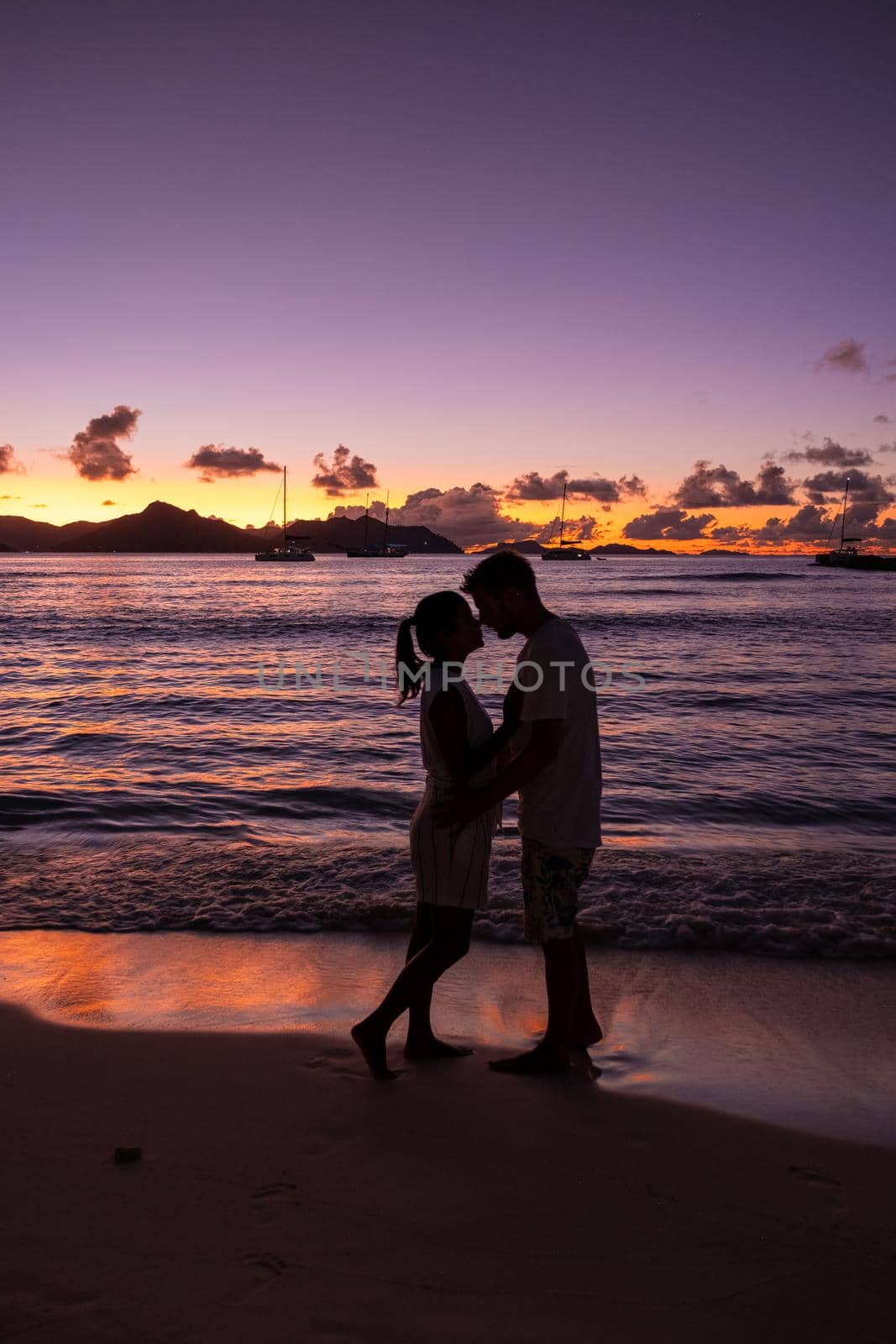 Anse Patates, La Digue Seychelles, a young couple of men and women on a tropical beach during a luxury vacation in Seychelles. Tropical beach Anse Patates, La Digue Seychelles