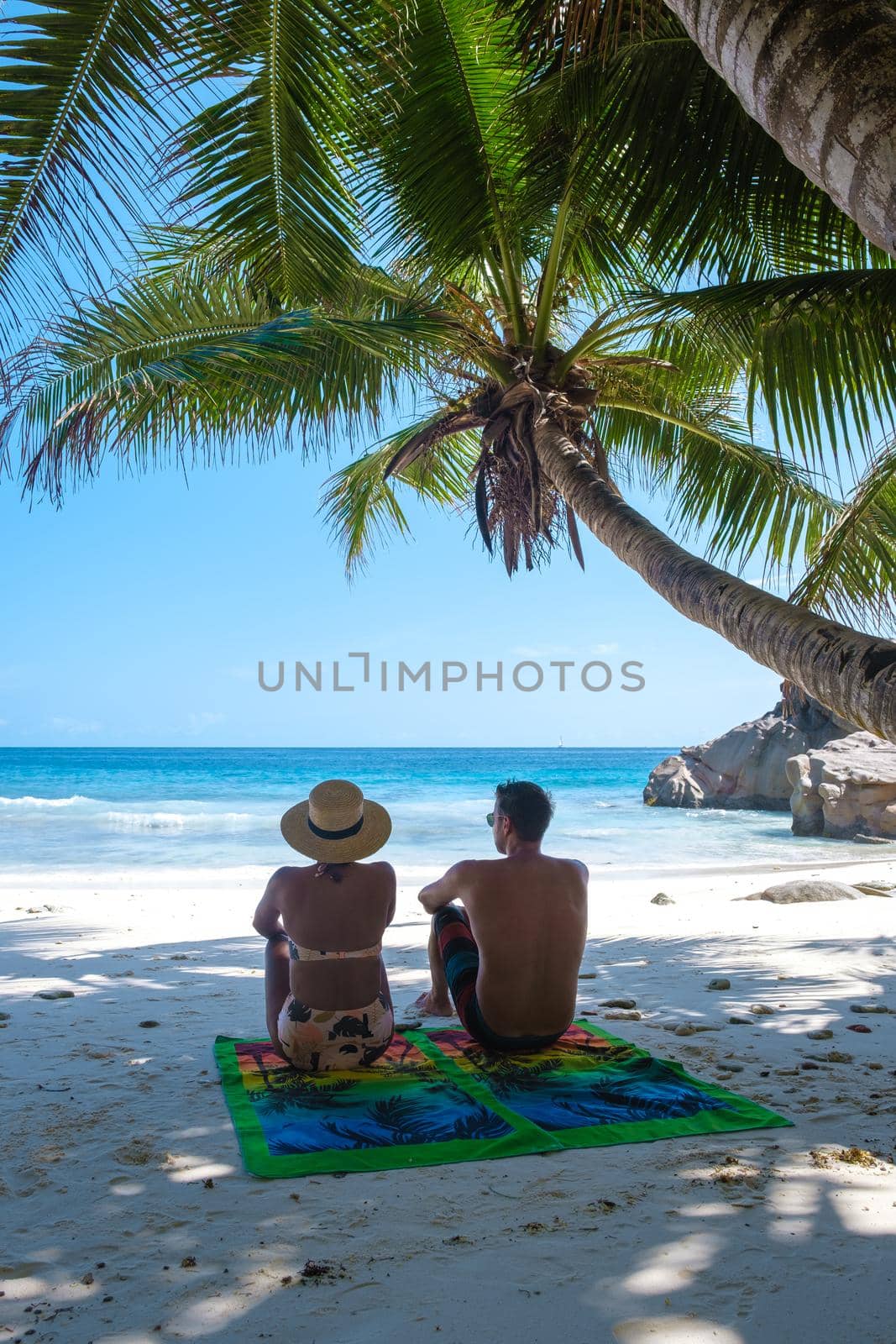 Anse Patates, La Digue Seychelles, a young couple of men and women on a tropical beach during a luxury vacation in Seychelles. Tropical beach Anse Patates, La Digue Seychelles