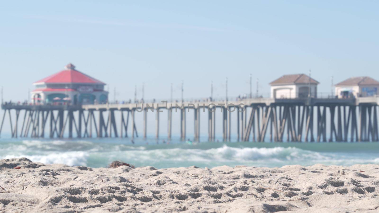 Retro huntington pier, surfing in ocean waves and sandy beach, California coast near Los Angeles, USA. American diner, sea water, beachfront boardwalk, summer vacations. Seamless looped cinemagraph.