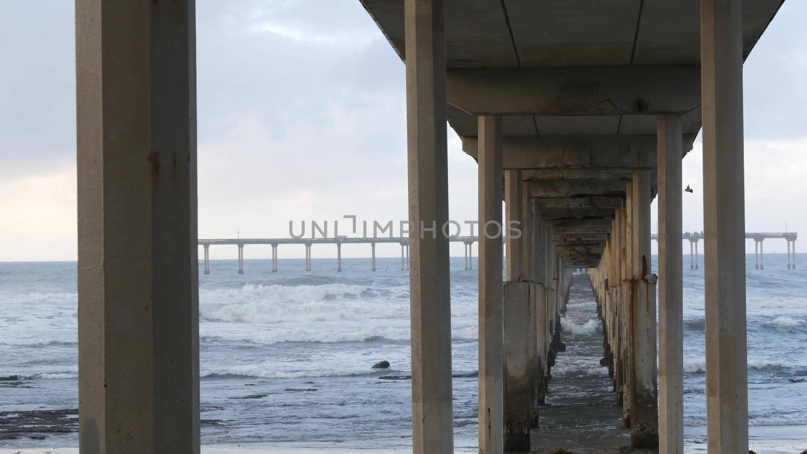 Ocean Beach pier in rainy weather, sea waves in rainfall, California coast, USA. by DogoraSun