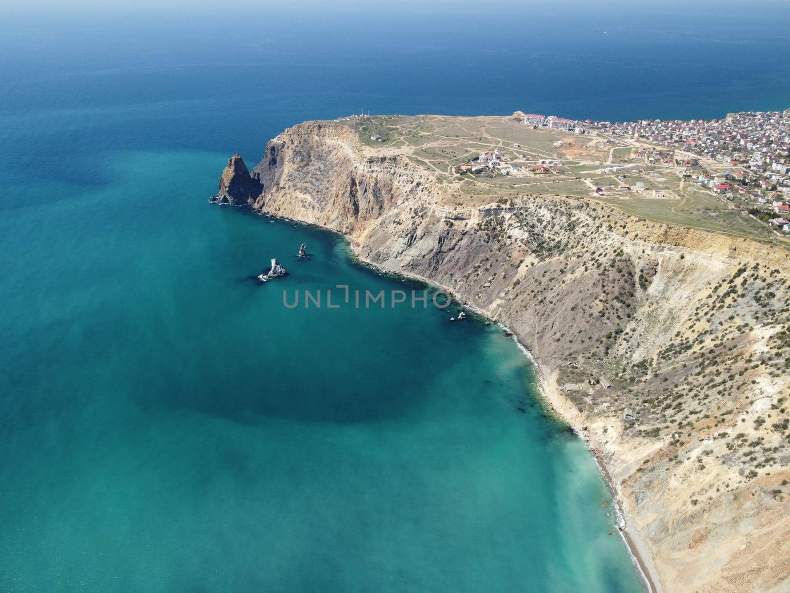 Aerial view on calm azure sea and volcanic rocky shores. Small waves on water surface in motion blur. Nature summer ocean sea beach background. Nobody. Holiday, vacation and travel concept by panophotograph