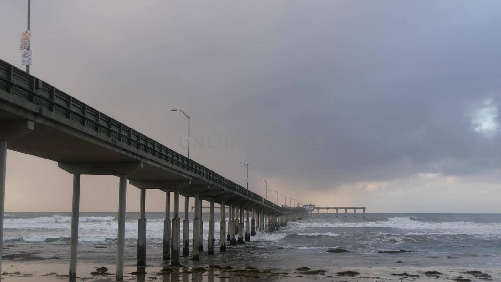 Ocean Beach pier in rainy weather, sea waves in rainfall, California coast, USA. by DogoraSun