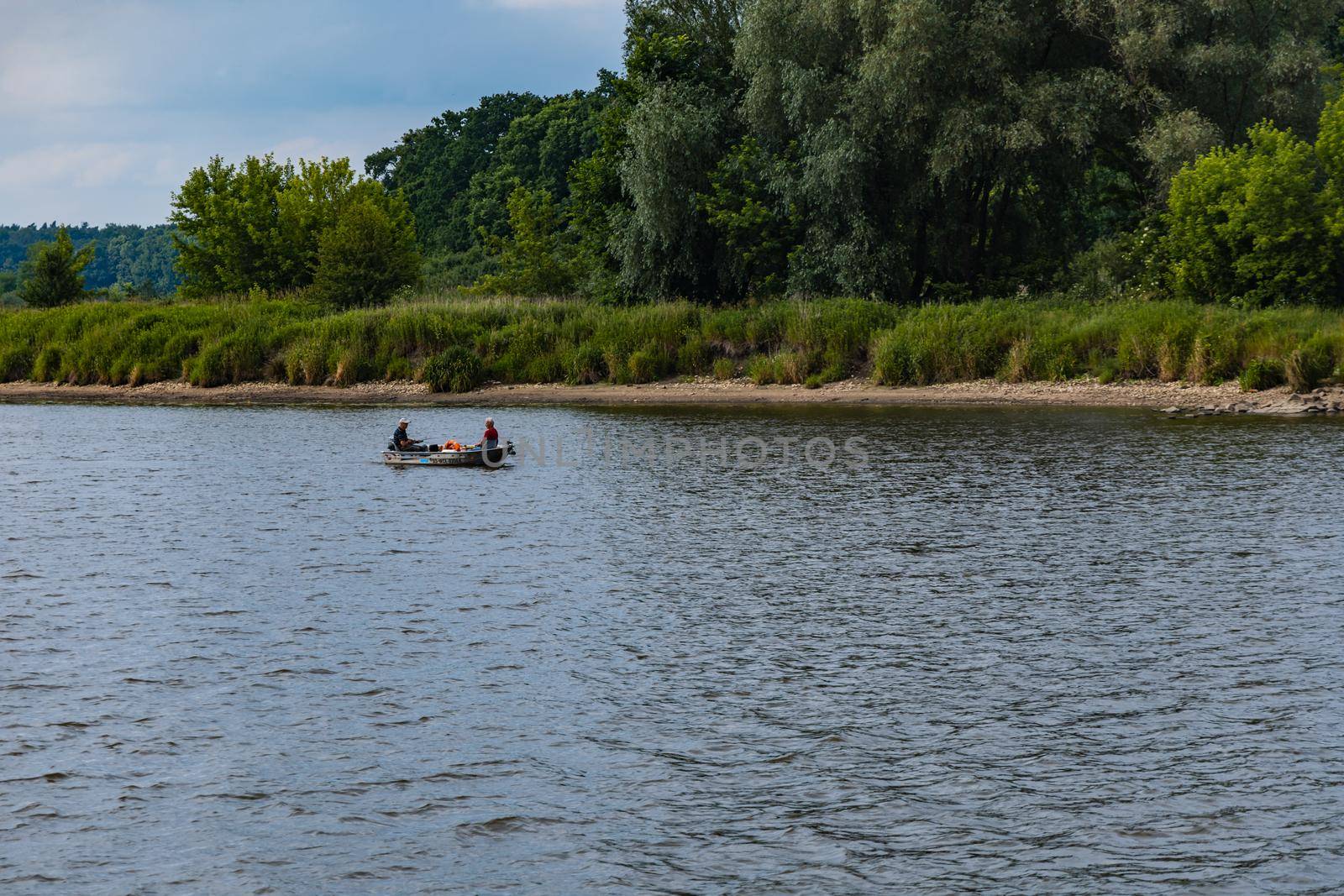 Two people swimming in small boat through river