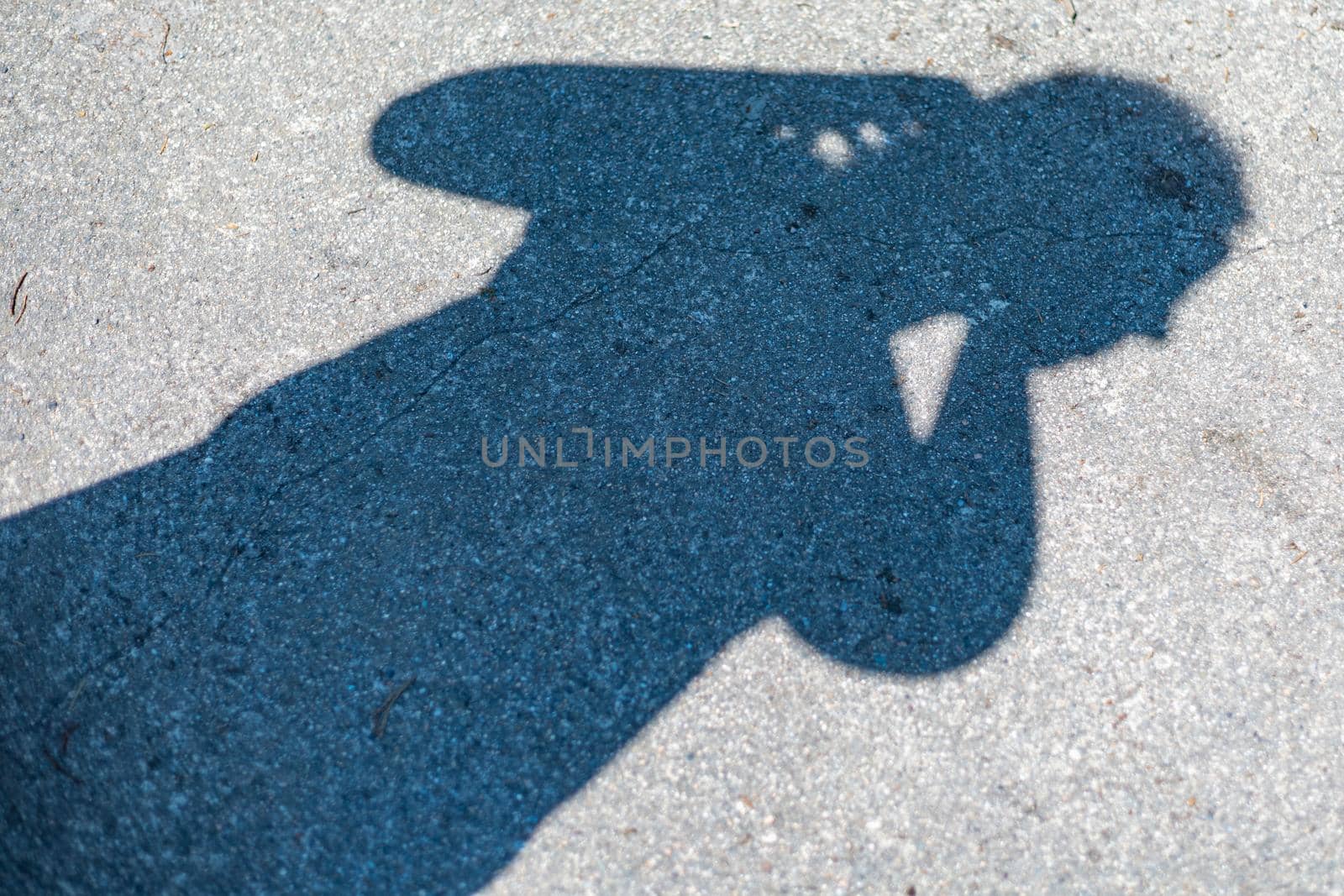 Shadow of person with camera on concrete floor