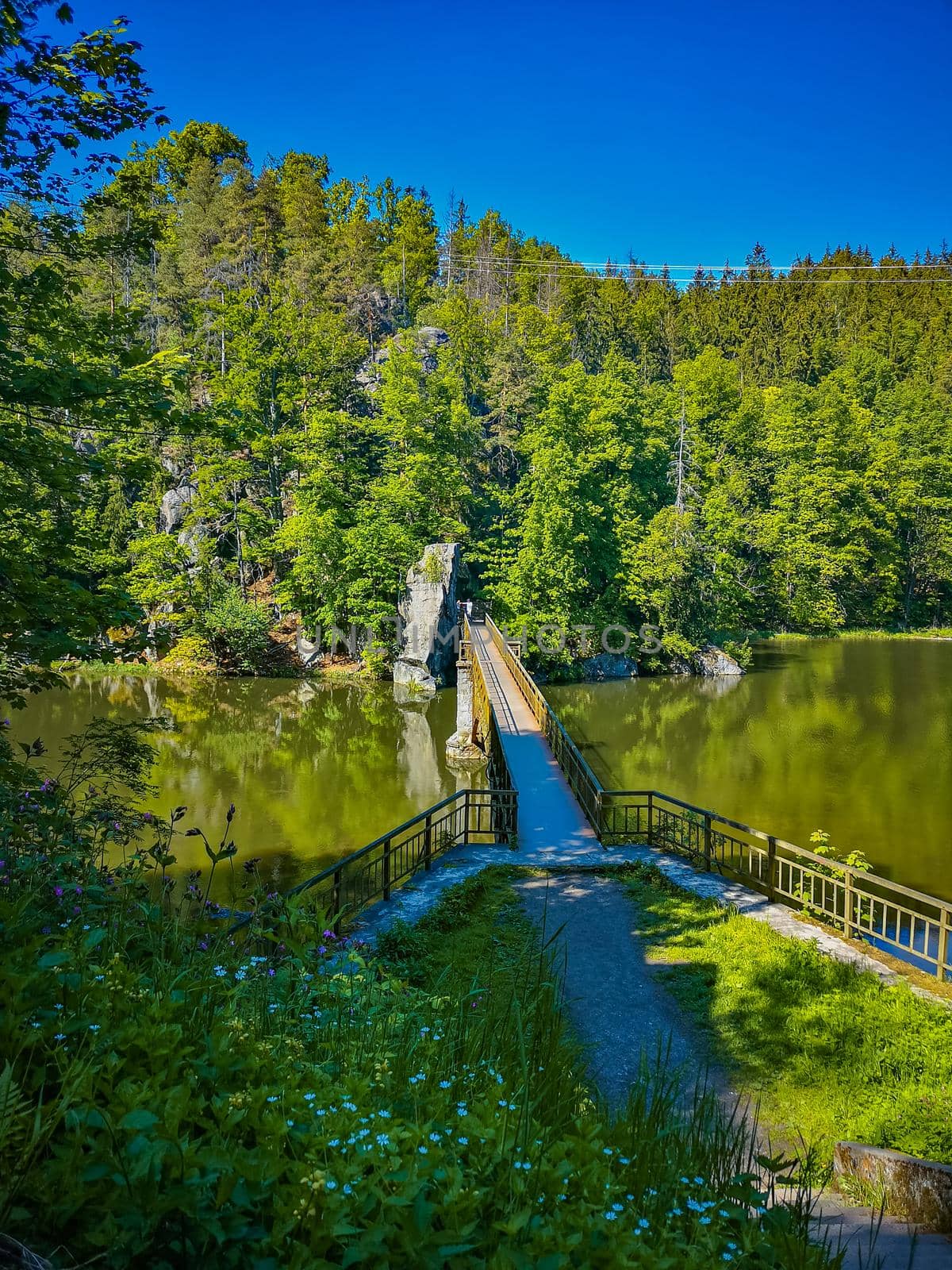 Long steel hanging footbridge over Modre lake by Wierzchu