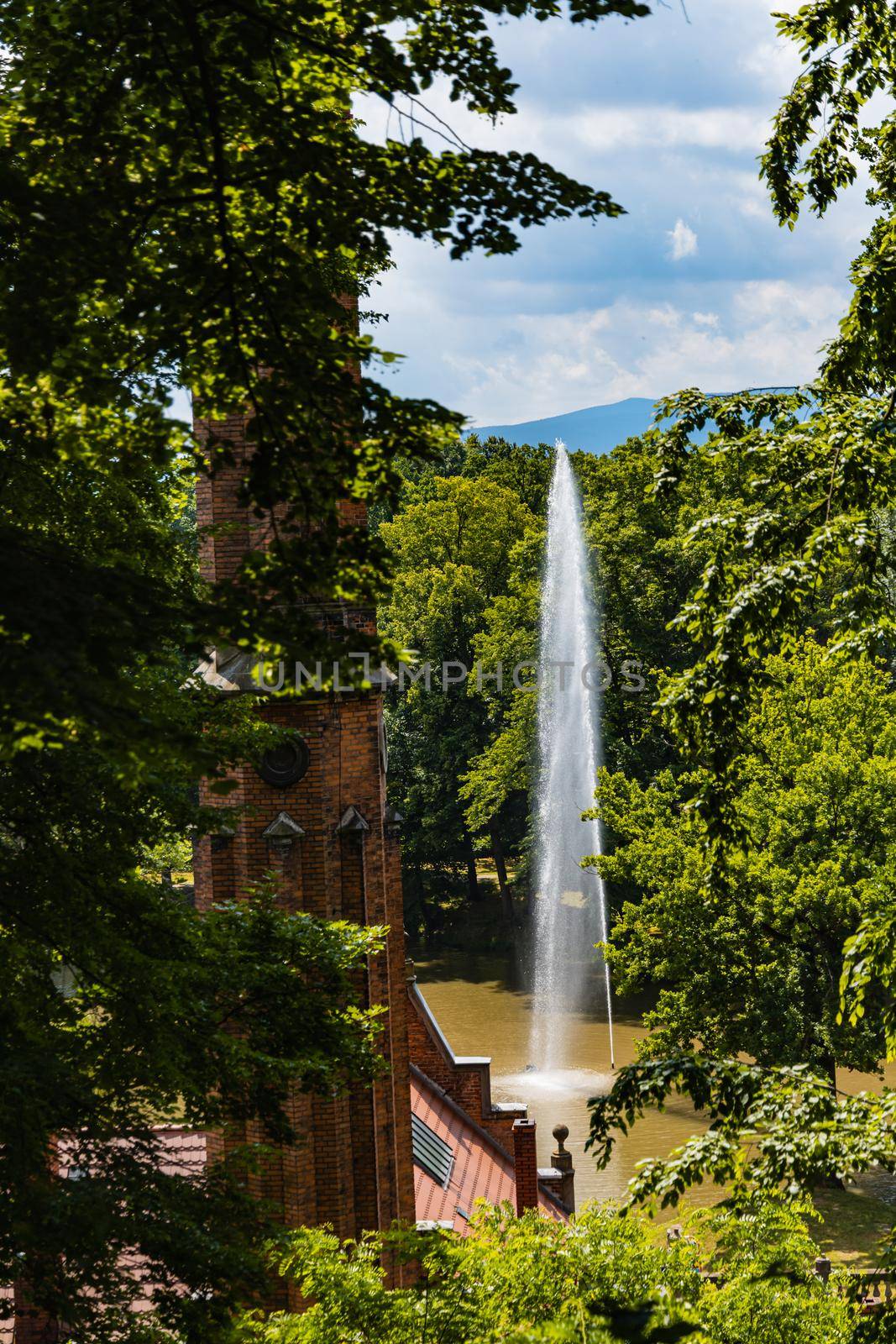 High fountain in small lake in valley in park by Wierzchu