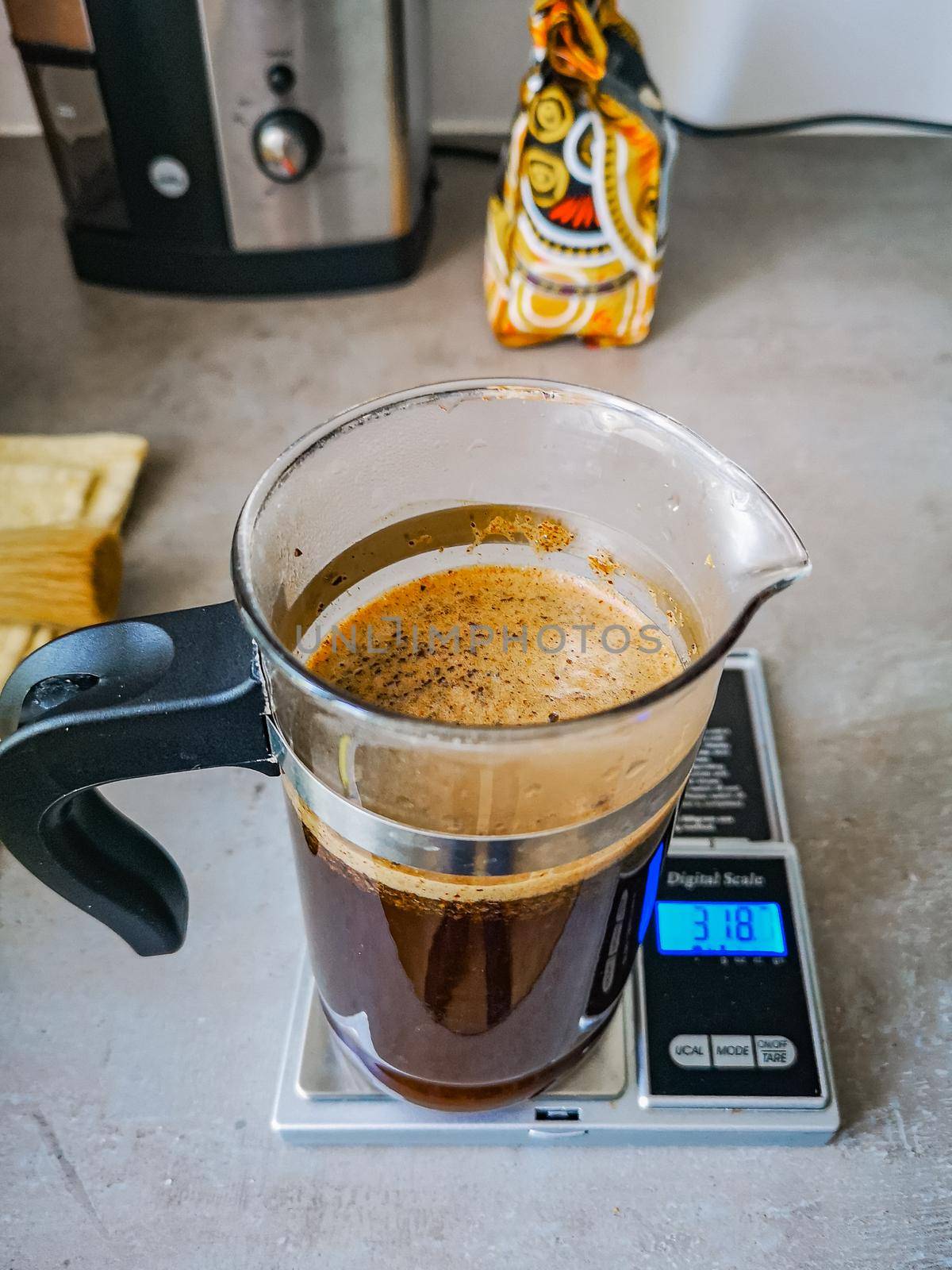 Small jug of coffee standing on small electronic weight