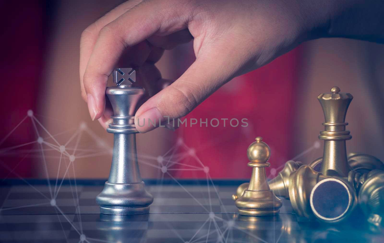 Hand businessman moving the golden knight chess fighting silver knight with fire sparks chess on chess board to successfully in the competition. Management or leadership strategy and teamwork concept.