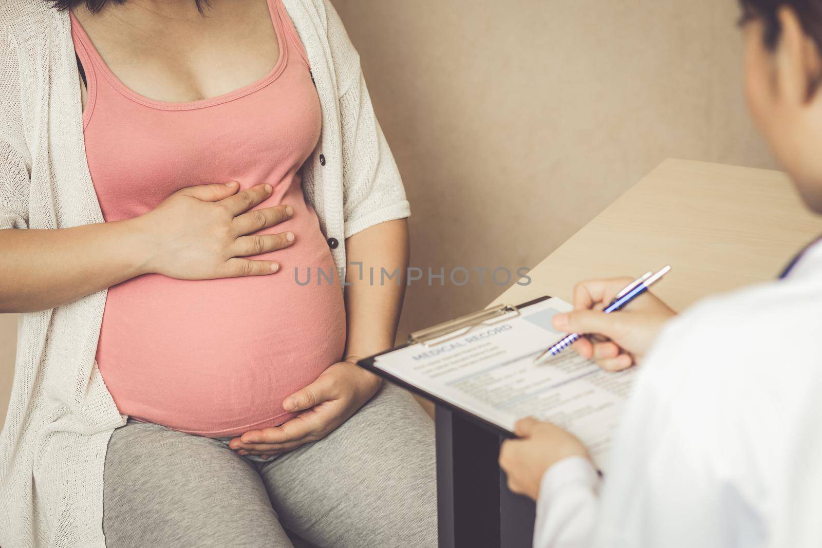 Happy pregnant woman visit gynecologist doctor at hospital or medical clinic for pregnancy consultant. Doctor examine pregnant belly for baby and mother healthcare check up. Gynecology concept.
