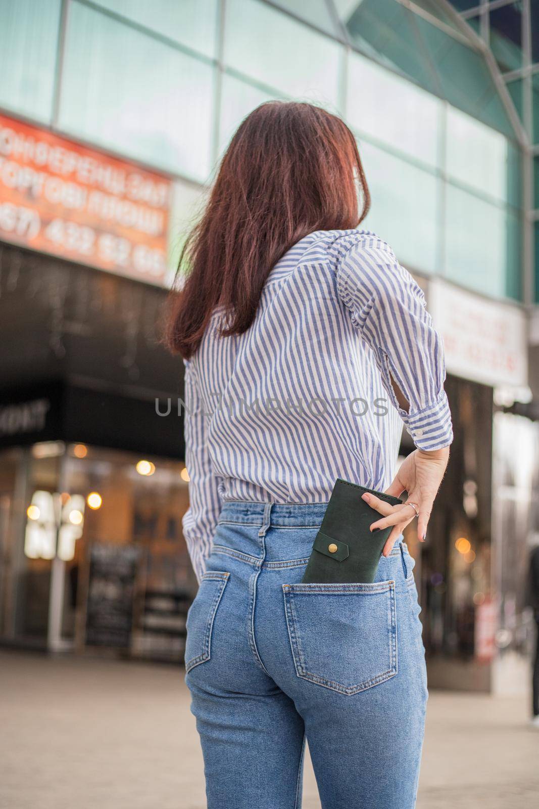 Confident woman posing in save keeping your wallet in the back pocket in pants
