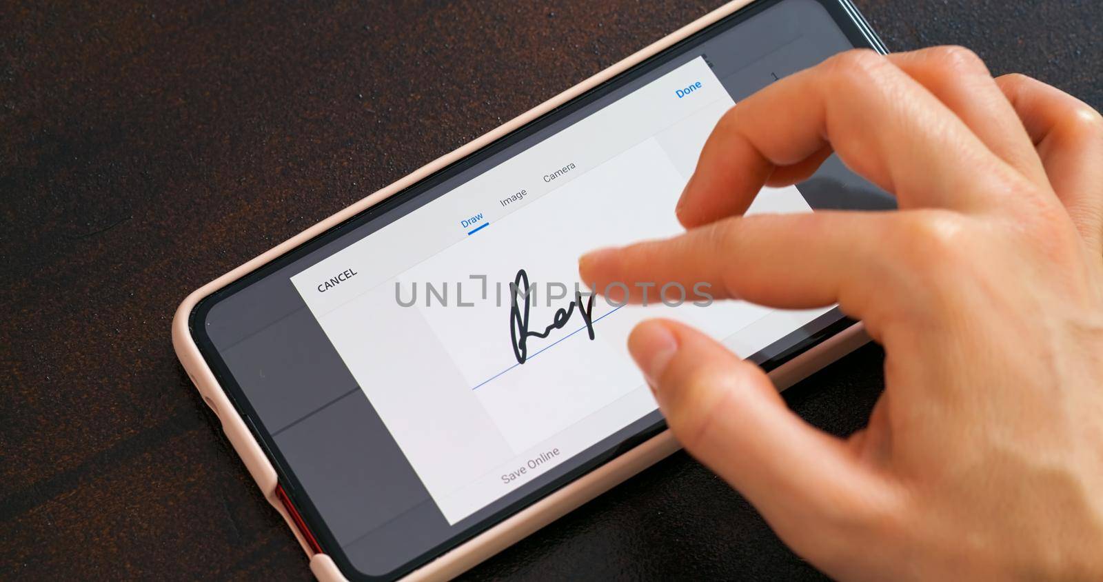 Electonic signature with finger in phone screen. Close up business office.