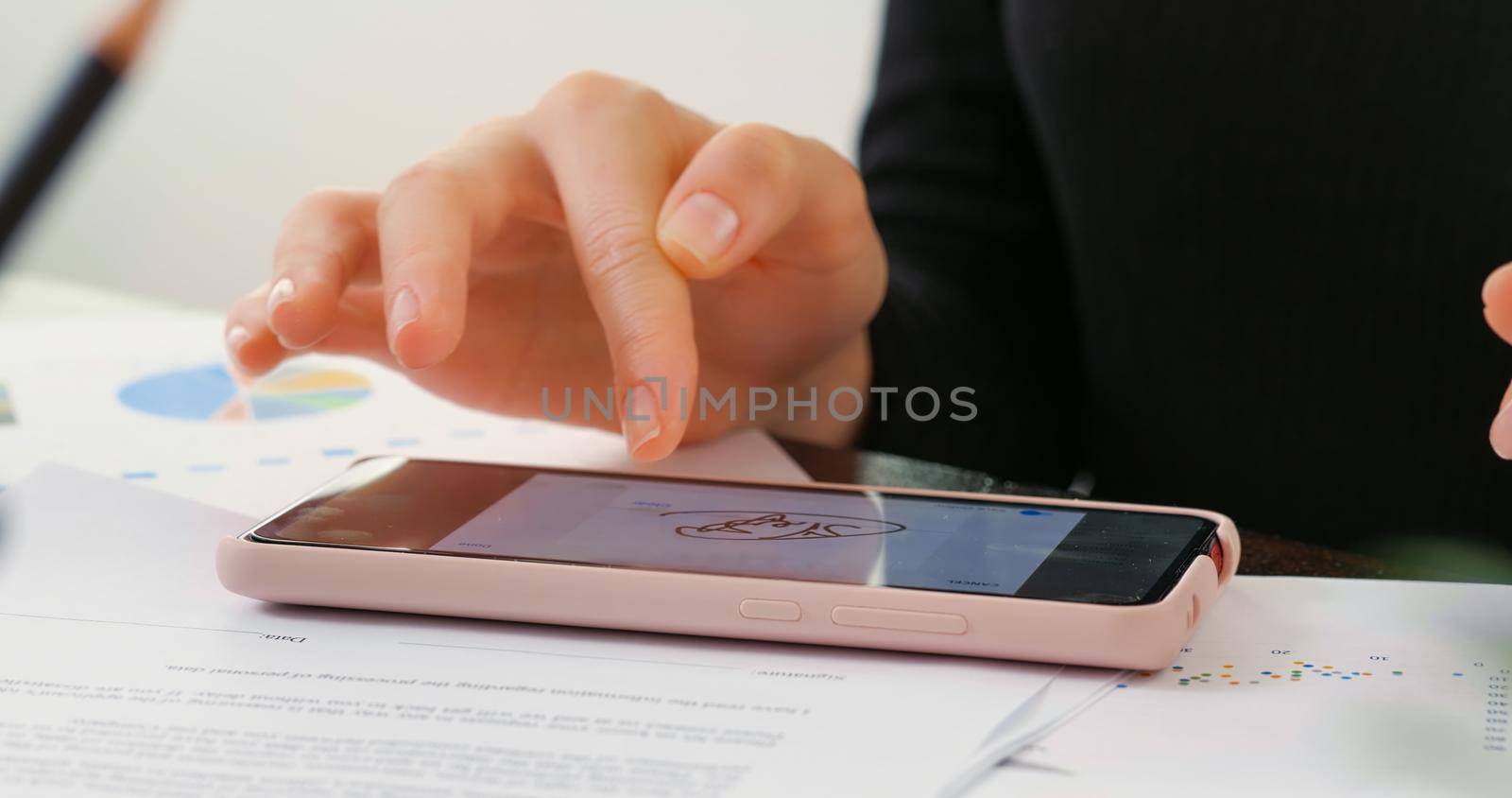 Digital Signature on smartphone screen with woman hand. Sign Document of Deal at Work in Office Indoors. Write Business Agreement for Entrepreneur. Contract electronic signature.