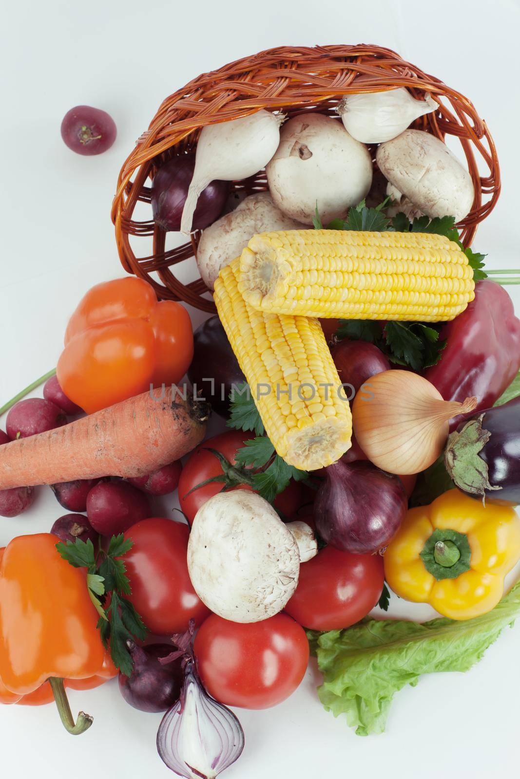 closeup.mushrooms and a variety of fresh vegetables in a wicker basket.isolated on a white background