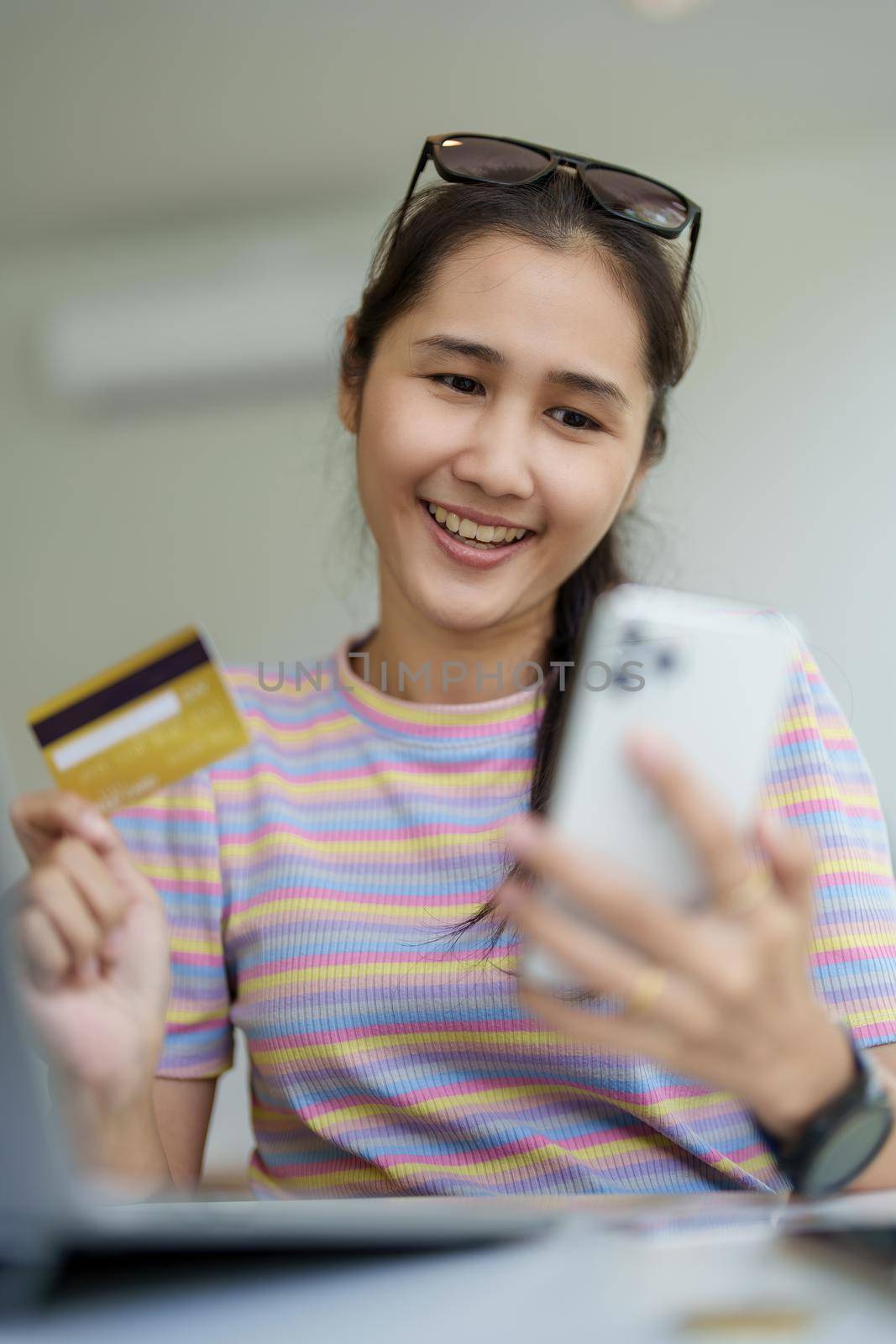 Online Shopping and Internet Payments, Portrait of Beautiful Asian women are using their credit cards and mobile phones to shop online or conduct errands in the digital world by Manastrong