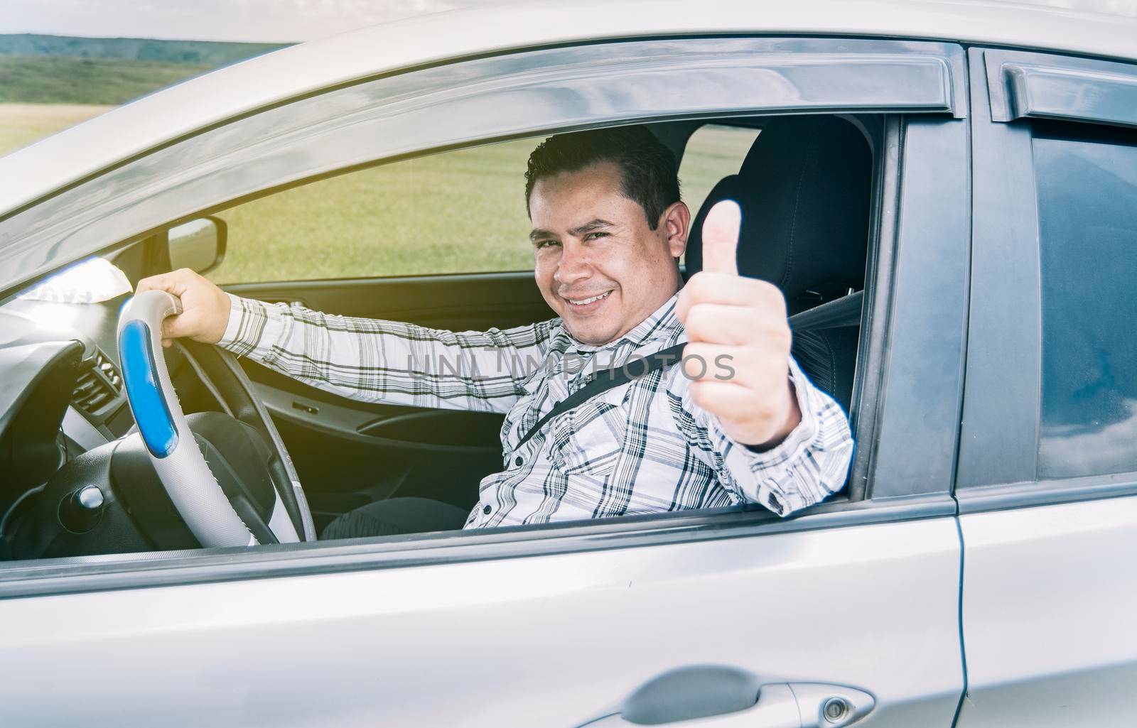 Happy man in his car giving a thumbs up, portrait of a man showing thumbs up while driving, Man in his car giving a thumbs up