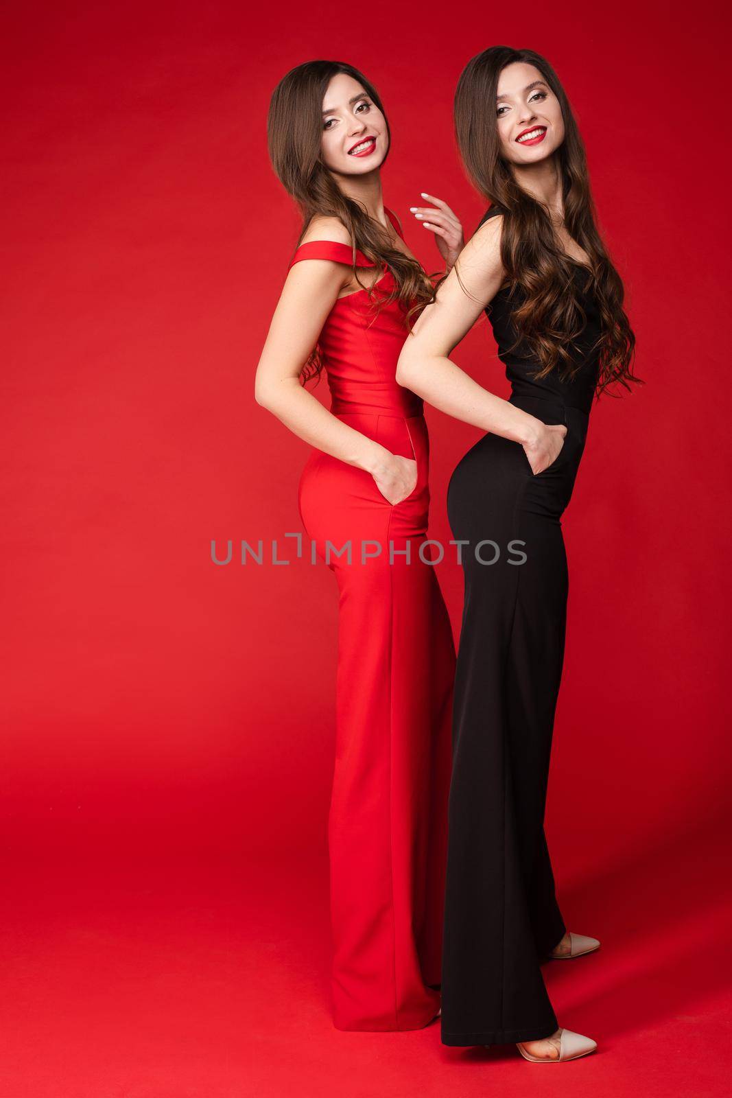 Young twins wearing similar black and red outfits and posing by StudioLucky