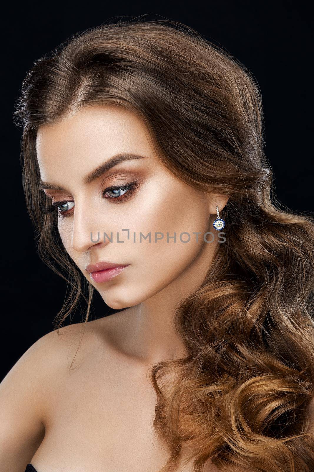 Studio fashion portrait of attractive sensual young woman with long wavy fair hair and blue eyes looking at camera. Natural beauty concept. Caucasian.