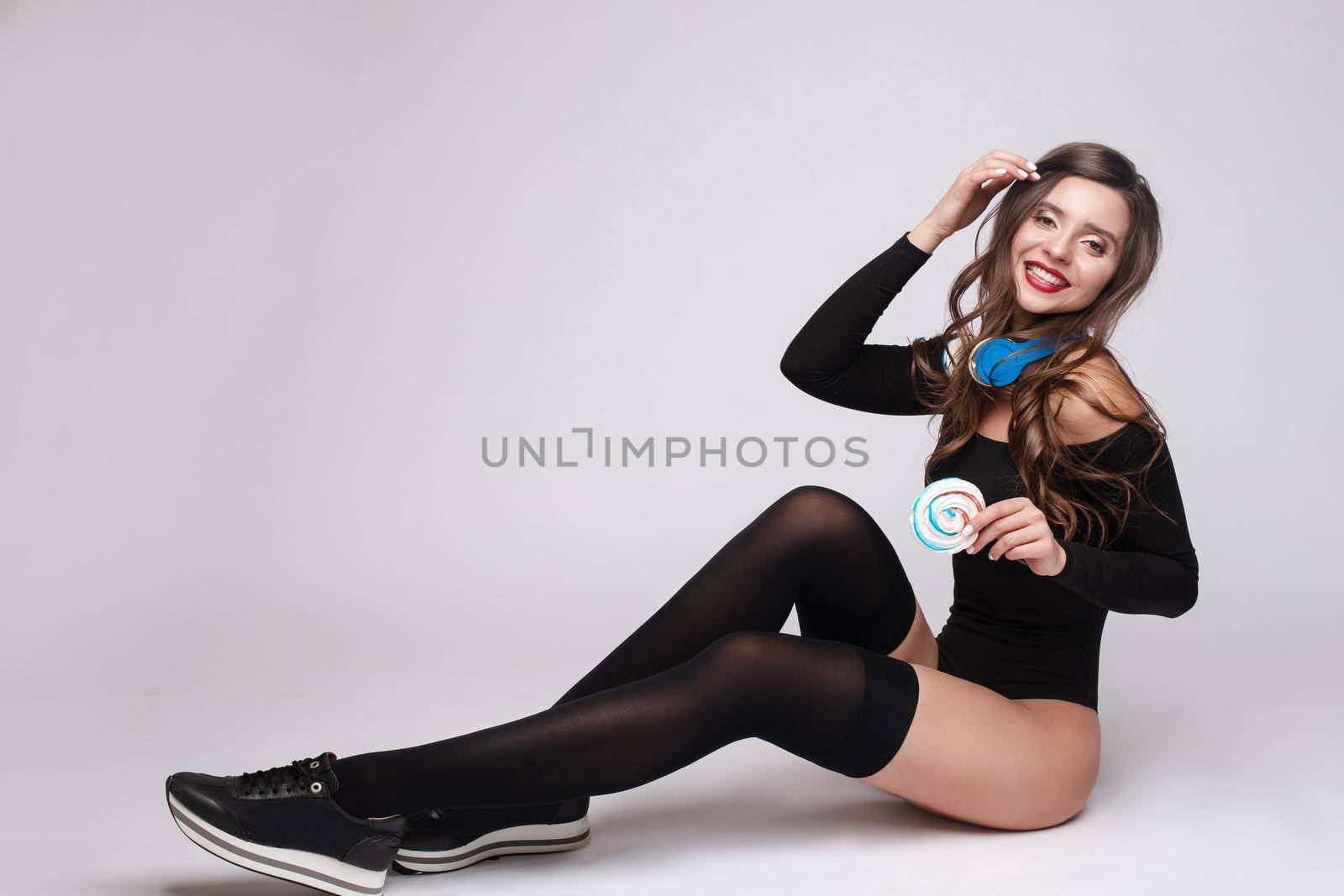 Girl in sneakers, stockings and body and listening music by StudioLucky