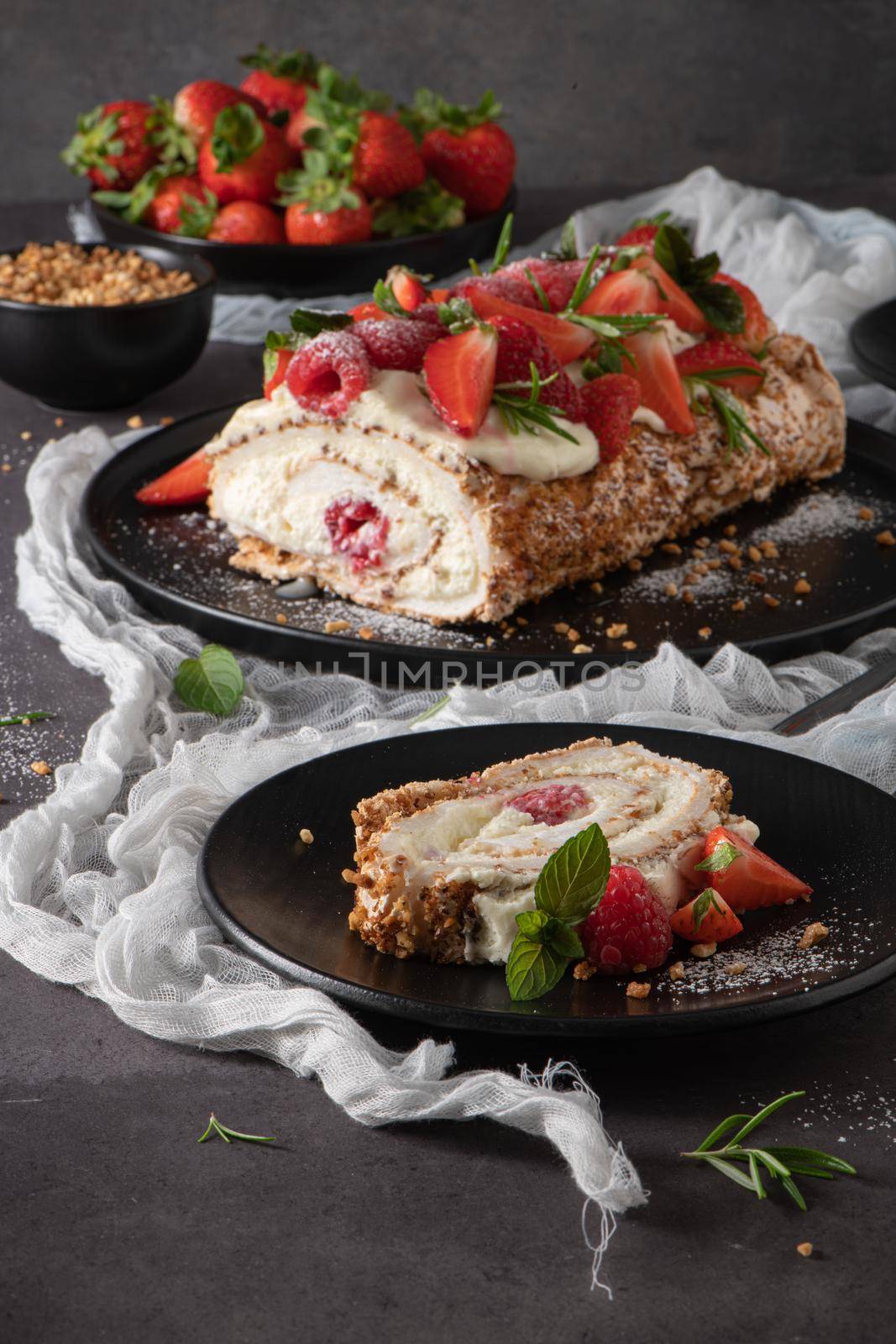 Meringue roll cake with cream, raspberries. Roulade, summer dessert served in ceramic plate.