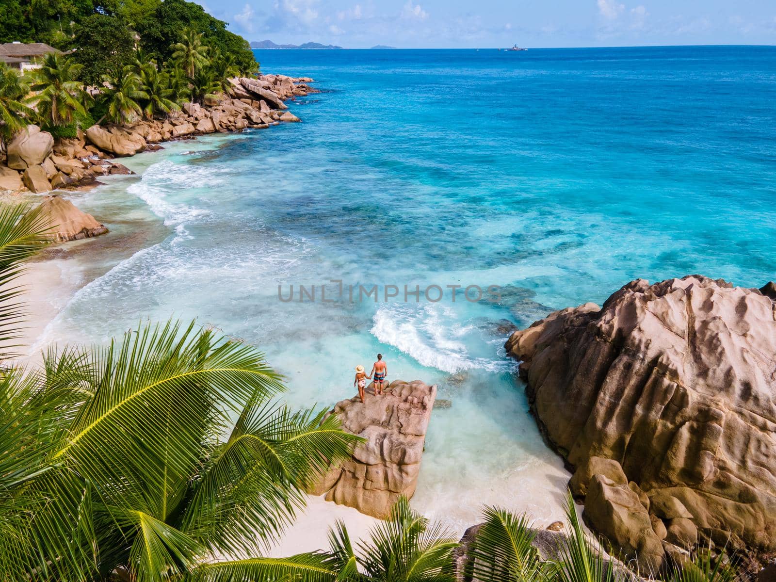 Anse Patates, La Digue Seychelles, young couple men and woman on a tropical beach during a luxury vacation in the Seychelles. Tropical beach Anse Patates, La Digue Seychelles by fokkebok