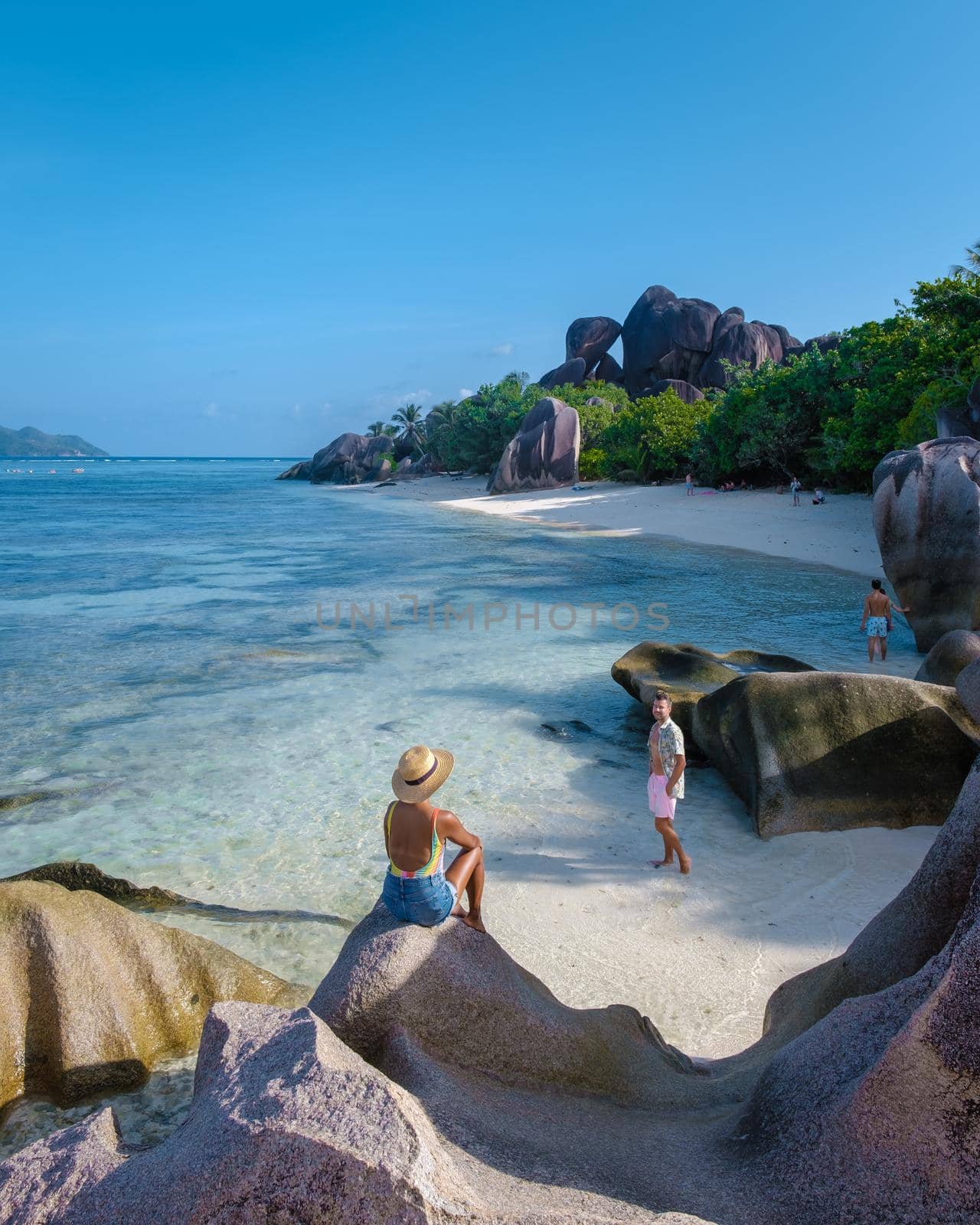 Anse Source d'Argent, La Digue Seychelles, young couple men and woman on a tropical beach during a luxury vacation in the Seychelles. Tropical beach Anse Source d'Argent, La Digue Seychelles by fokkebok