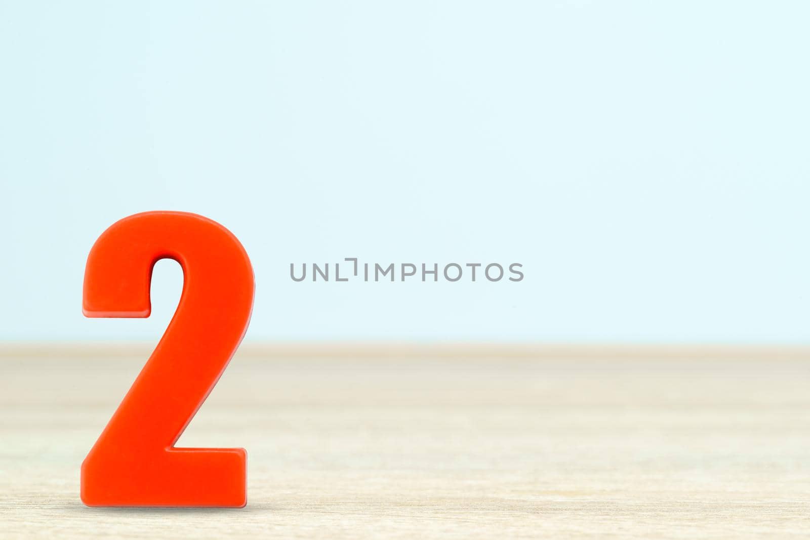 Shot of a number two made of red plastic on table with copy space